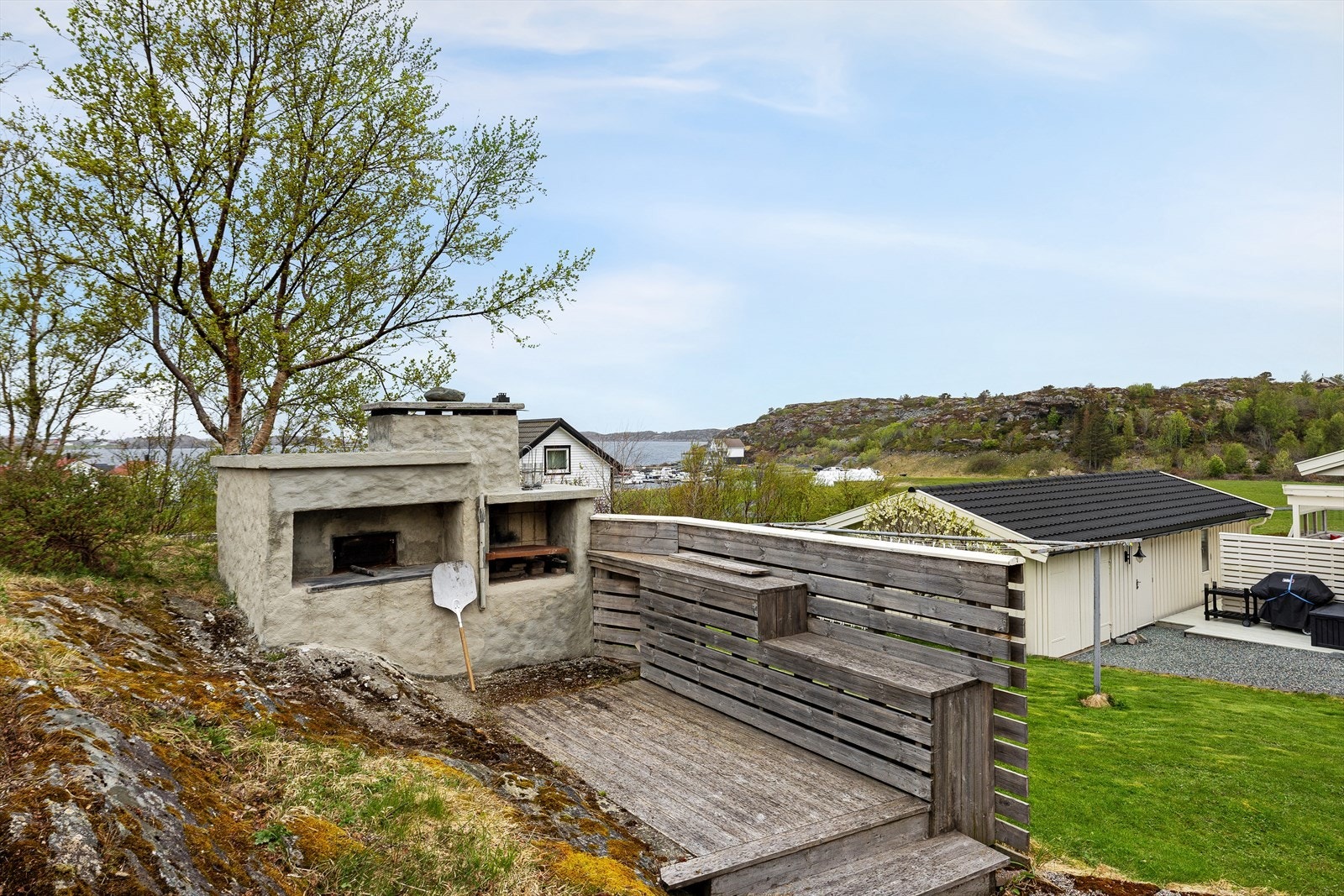 Flott opparbeidet uteområde med steinovn som setter rammen for sosiale og minnerike sommerdager ved sjøen. Galleribilde
