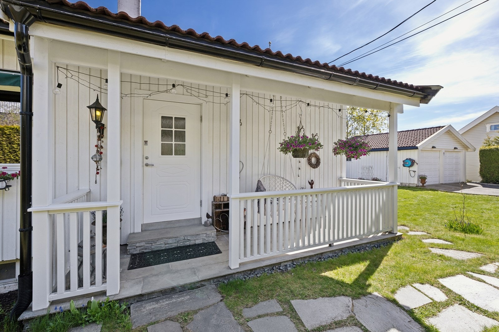 Overbygget inngangsparti med plass til en liten sittegruppe. Galleribilde
