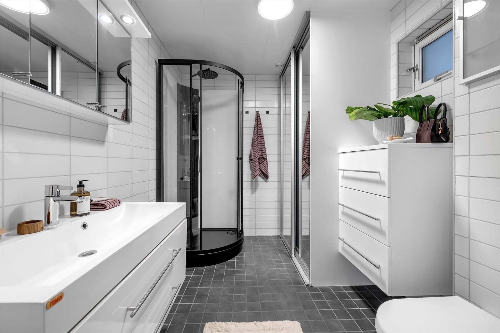 Badet er modernisert med fliser på gulv og vegger. Smart løsning med vaskemaskin og tørketrommel i garderobe. Galleribilde