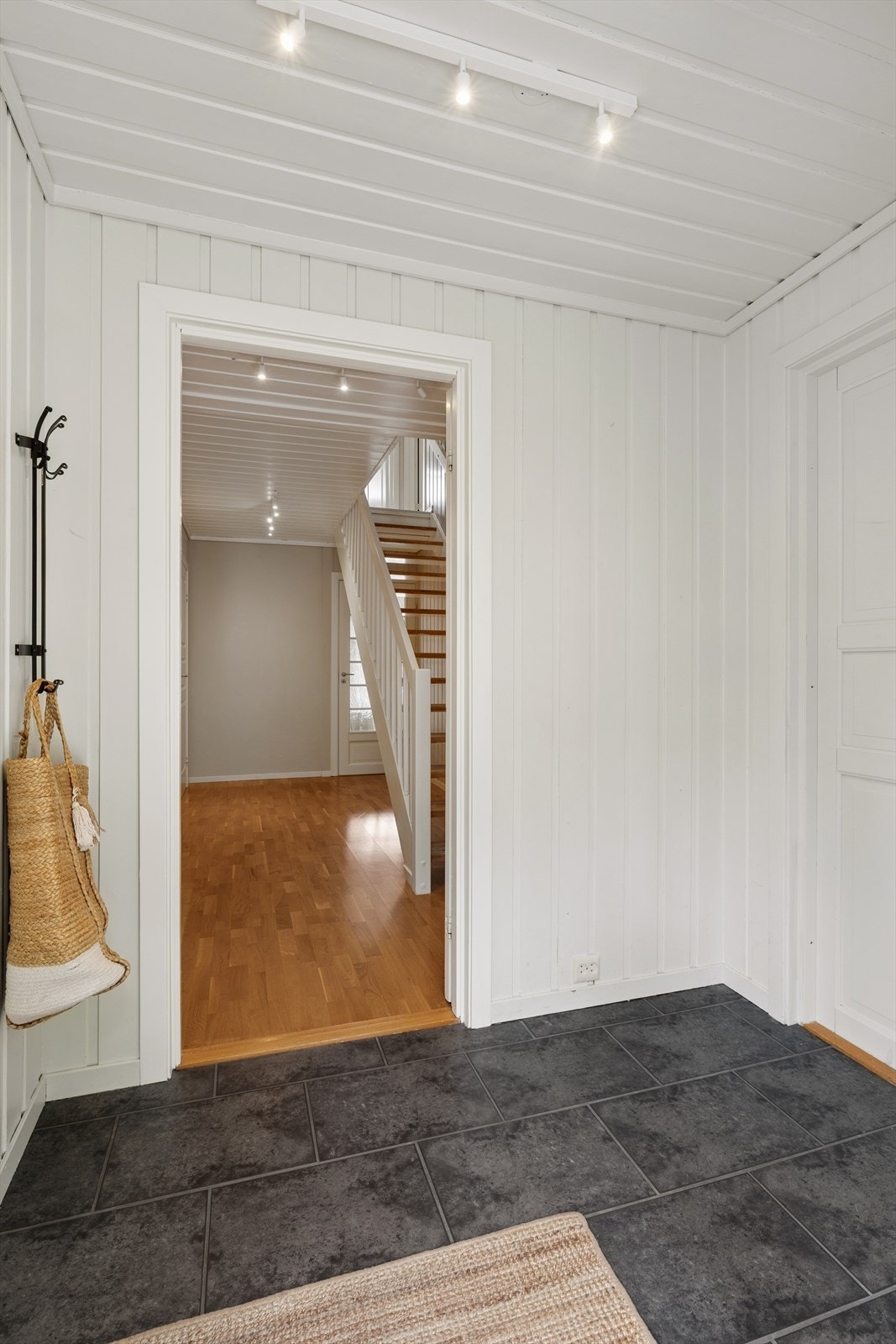 Velkommen inn! Fra inngangspartiet er det adkomst til vaskerom på venstre side, kjeller på høyre side, samt videre ferdsel inn i boligen. Galleribilde