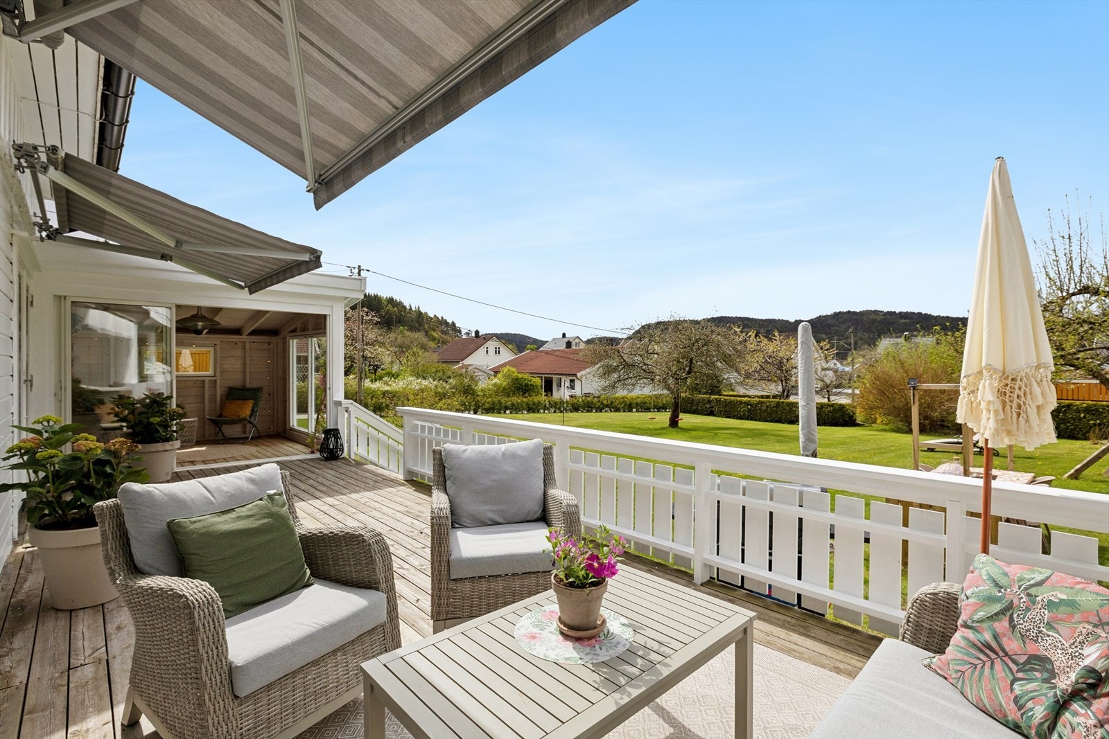 Vi tar turen ut til boligens uteområde som fremstår svært innbydende og godt tilrettelagt for hyggelige stunder utendørs. Den romslige terrassen
har god plass til sittegrupper og er utstyrt med markiser som gir både sol- og leforhold etter behov. Galleribilde