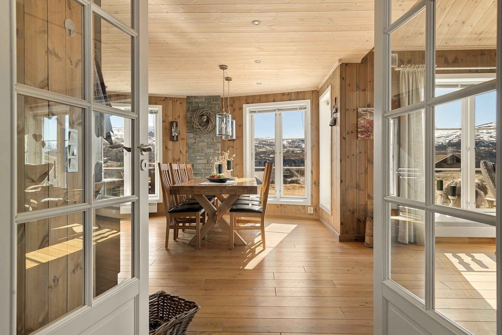 Når du trer inn i stuen, er det umulig å ikke bli imponert av de store vindusflatene som rammer inn utsikten mot de omkringliggende fjellene Galleribilde