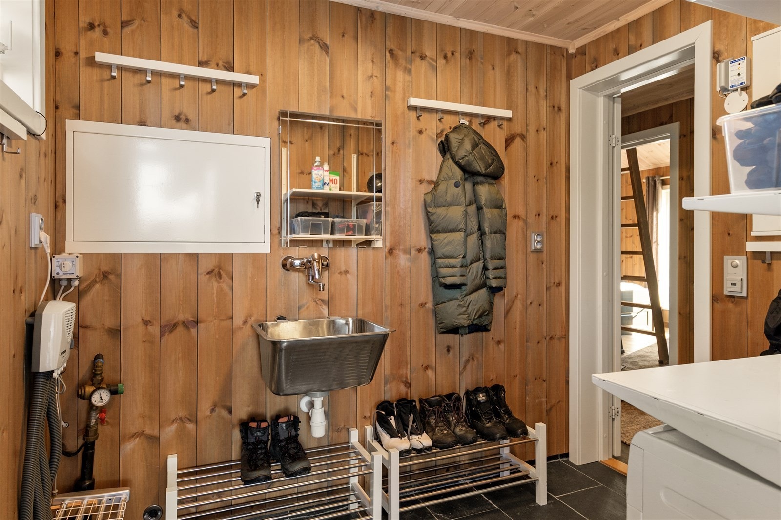 Rett ved badet ligger et praktisk teknisk rom med oppbevaringsplass for yttertøy, samt varmtvannsbereder og sikringsskap. Galleribilde