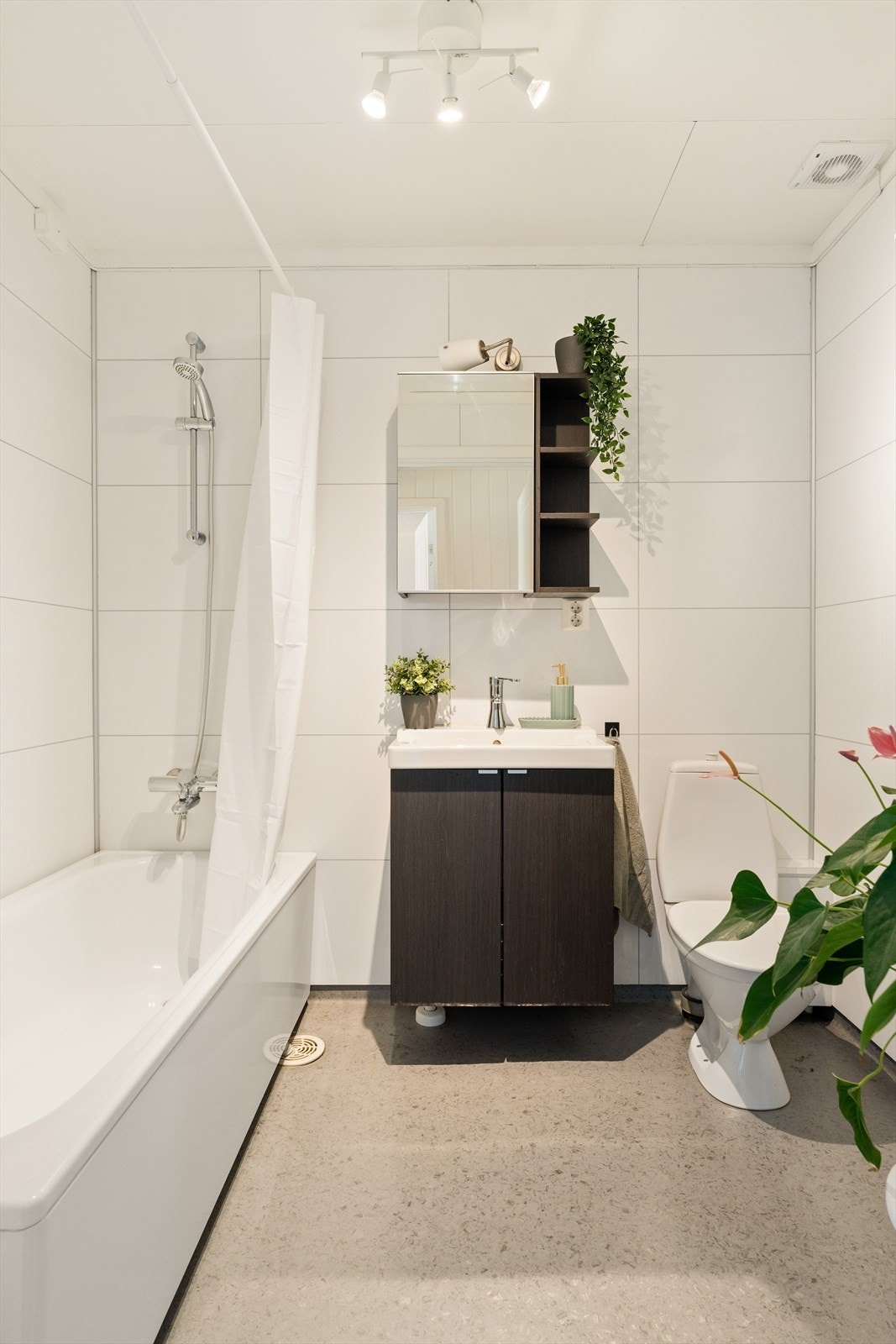 Badet består av servant med servantskap, gulvmontert toalett og badekar. Galleribilde