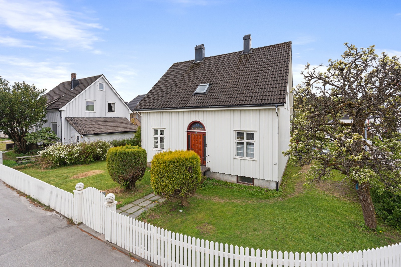 Boligen fra forsiden med koselig hvitt stakittgjerde rundt del av tomten Galleribilde