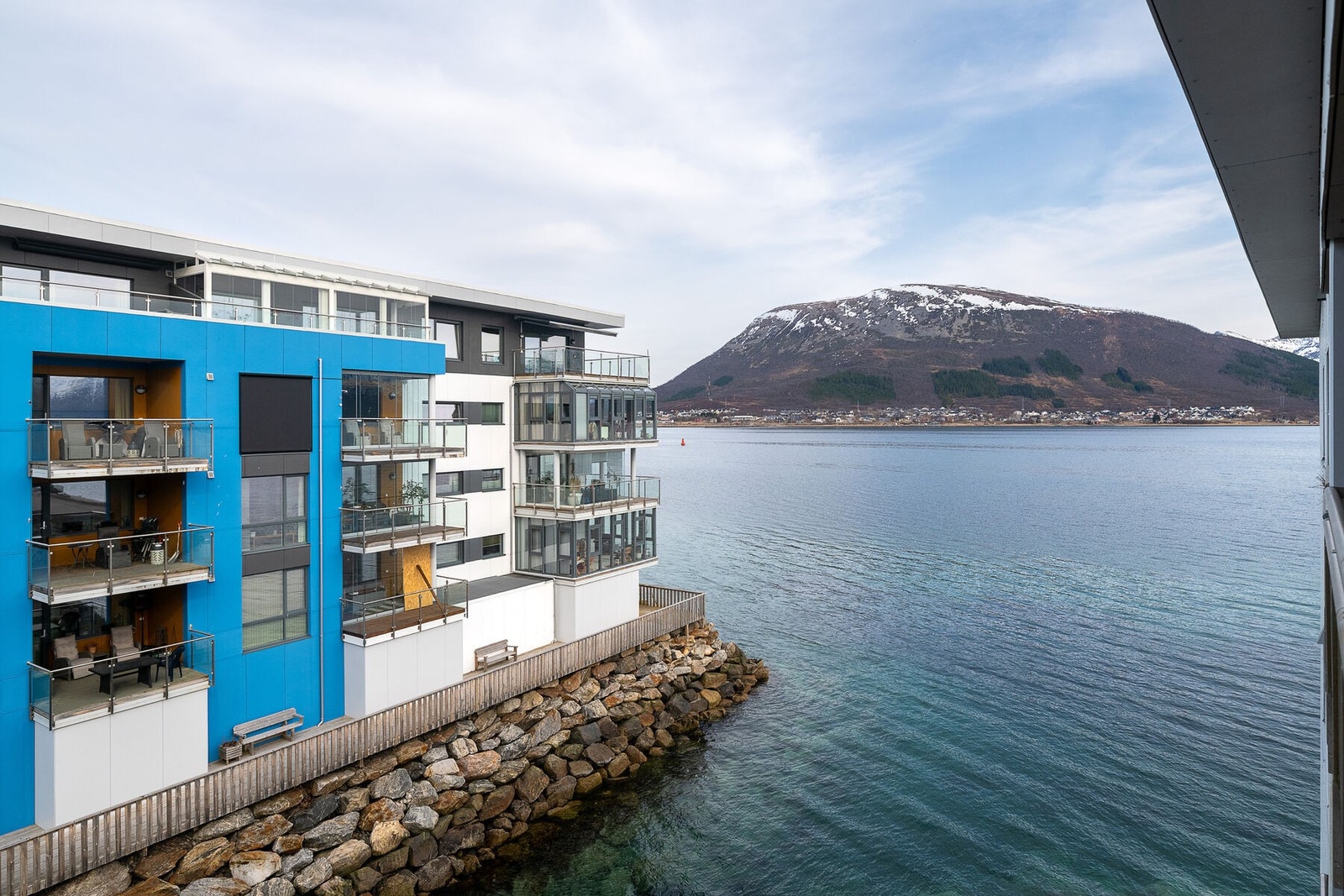 Leiligheten har adkomst via en overbygd svalgang. Her er utsikten fra svalgangen og inngangspartiet. Galleribilde