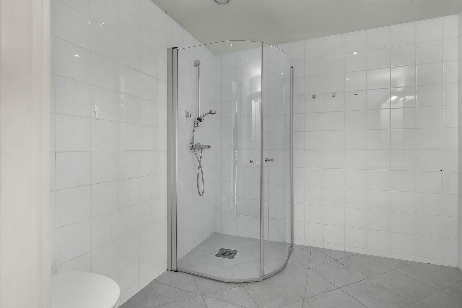 Dusjhjørne med buede glassdører. Det er balansert ventilasjon. Galleribilde