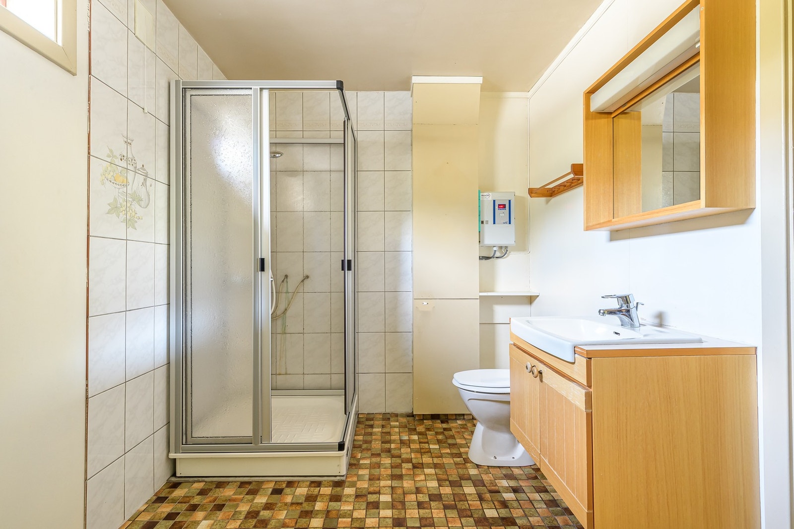 Badet i underetasjen har flislagt gulv med varme. Innredet med servantskap, dusjkabinett, toalett og opplegg for vaskemaskin. Galleribilde