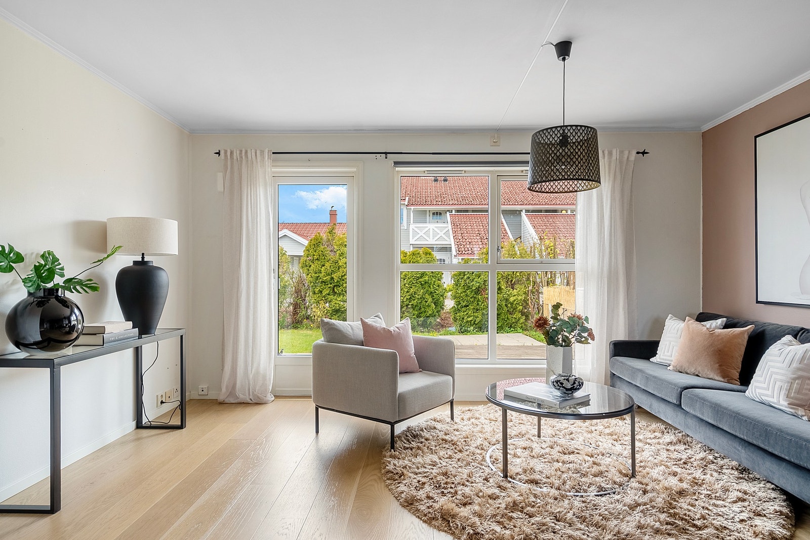 I stuen bidrar store vindusflater til å trekke deg inn i rommet og videre ut på uteplassen Galleribilde