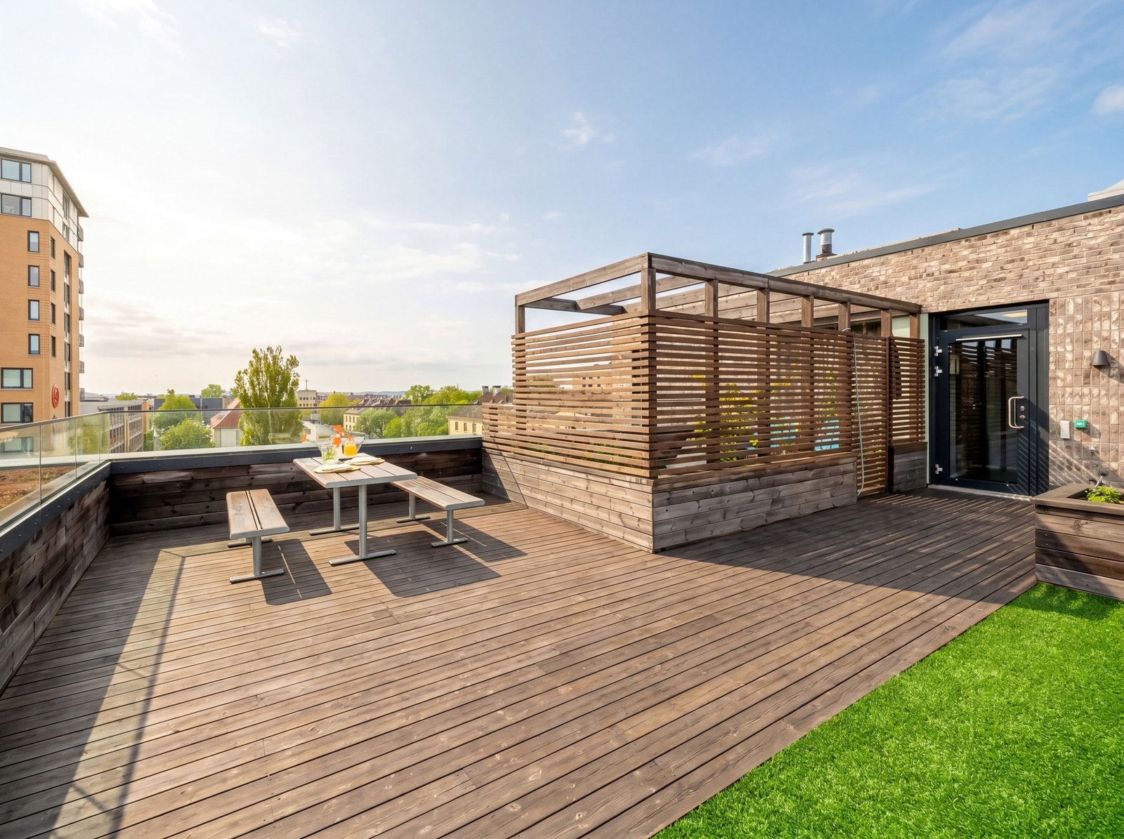 På toppen av bygget som leiligheten ligger i, er det en flott takterrasse til felles bruk. Bildet er KI-redigert for å illustrere sommerforhold og avvik kan forekomme. Galleribilde