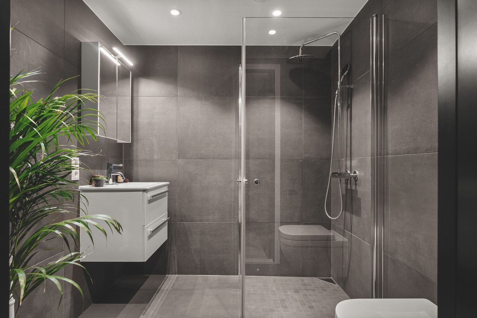 Boligen har et lekkert, flislagt bad fra byggeåret som er svært romslig. Badet er utstyrt med dusjnisje med glassdører, vegghengt toalett og servant med innredning. Rommet har opplegg for vaskemaskin og varme i gulv. Galleribilde