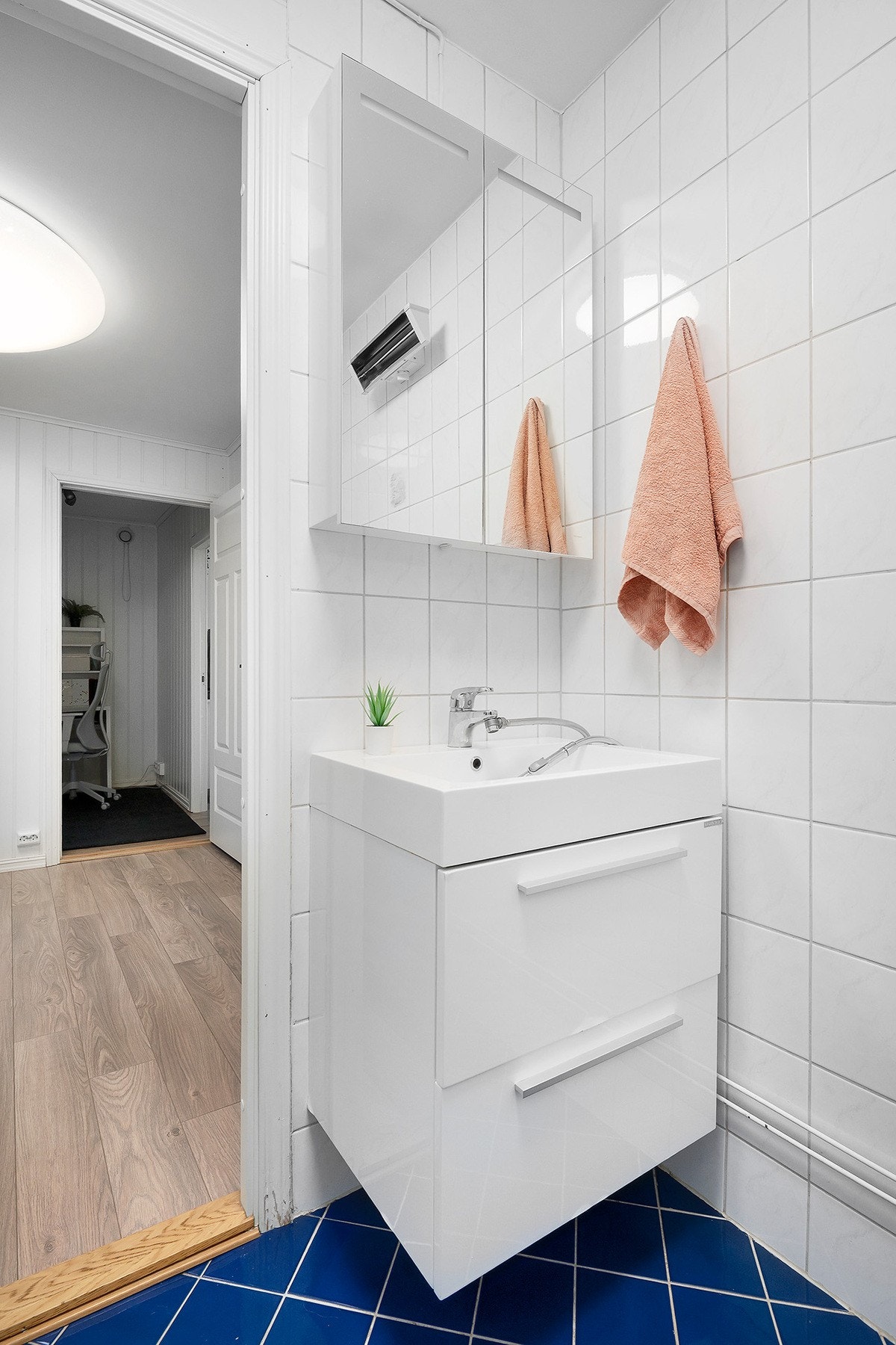 Badet er innredet med håndvask med innredning, speilskap, klosett og romslig dusjnisje med glassdører. Galleribilde