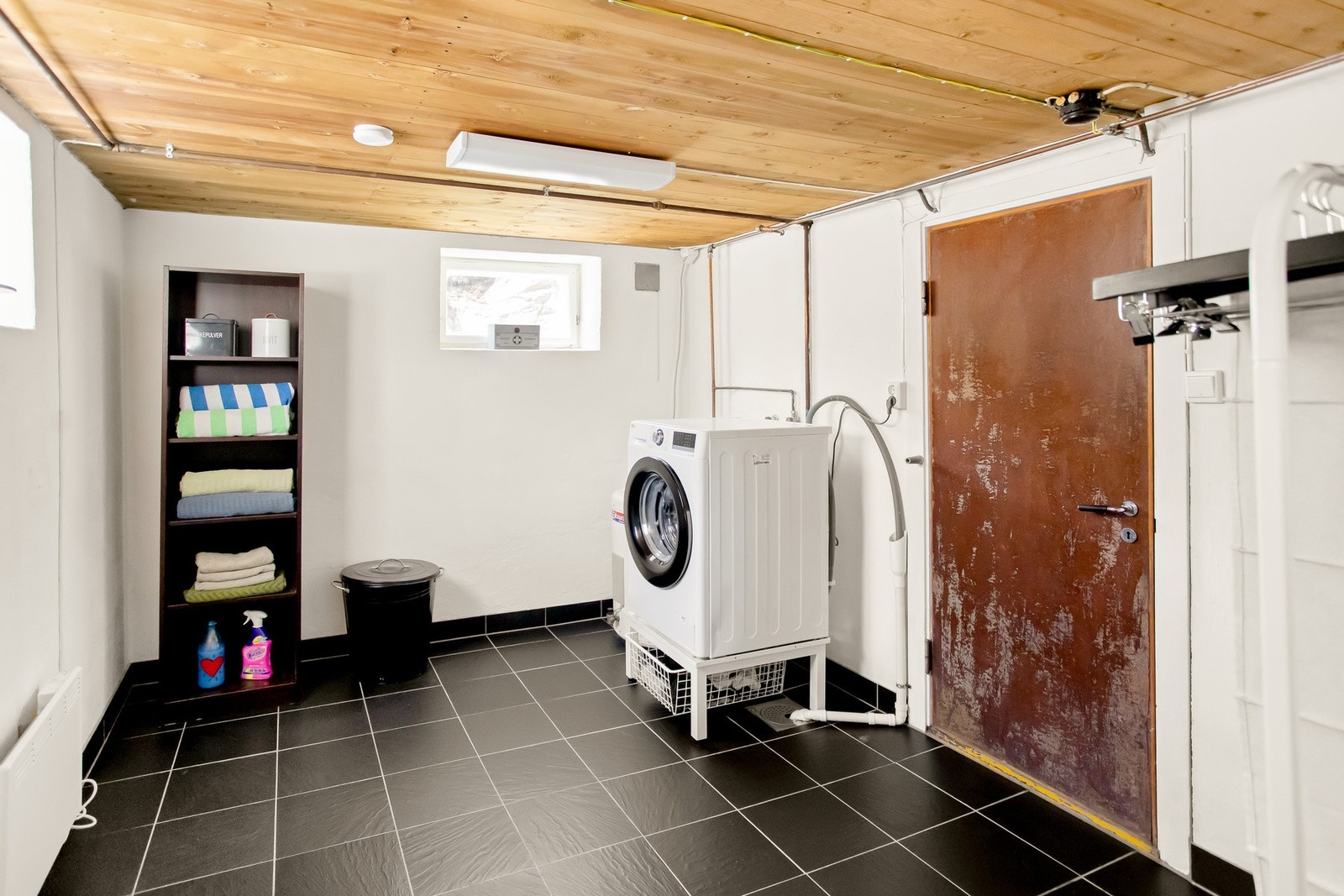 Badet/vaskerommet i kjelleren har dusjkabinett, servant og opplegg for vaskemaskin. Vaskemaskin med stativ følger med i salget Galleribilde