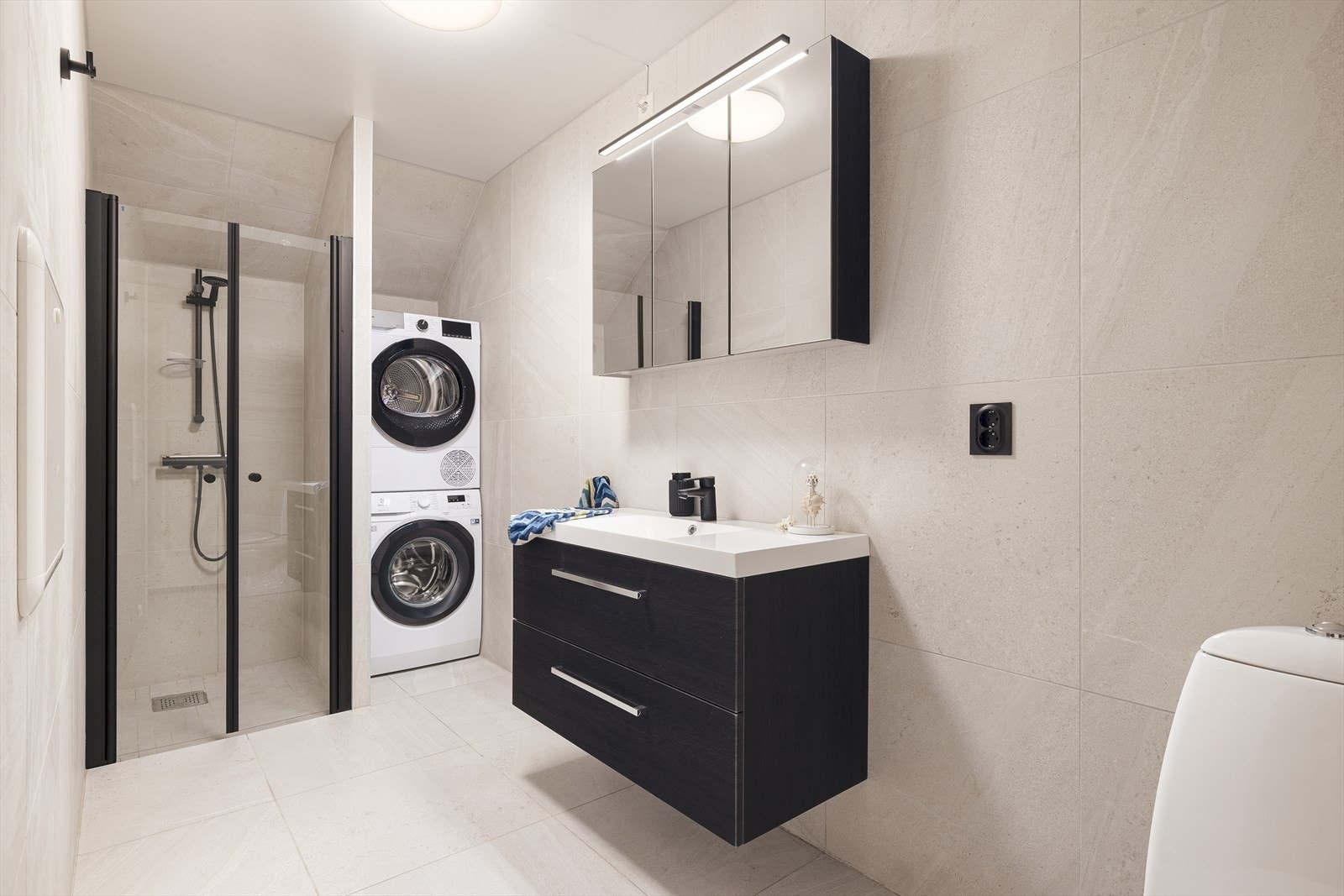 Moderne og stilrent bad med flislagte gulv og veggflater. Badet er opplyst å være nyoppført/totalrenovert i 2024/2025 Galleribilde
