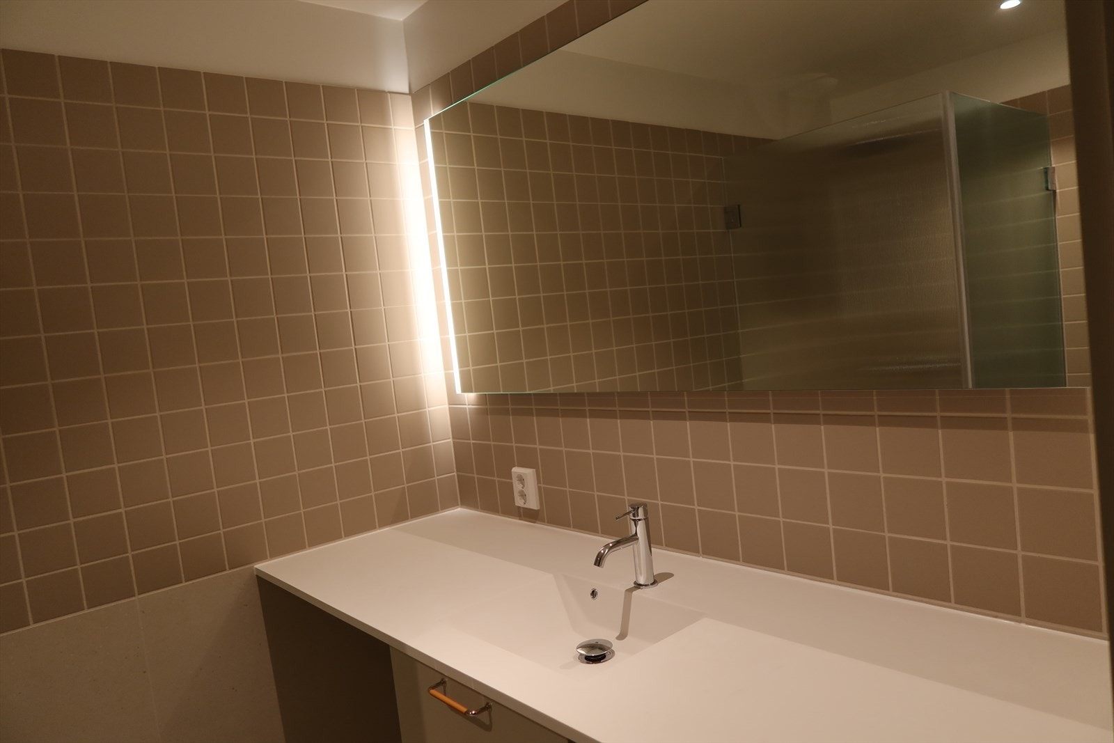 Moderne flislagt bad med vannbåren gulvvarme. Opplegg for vaskemaskin og tørketrommel. Galleribilde