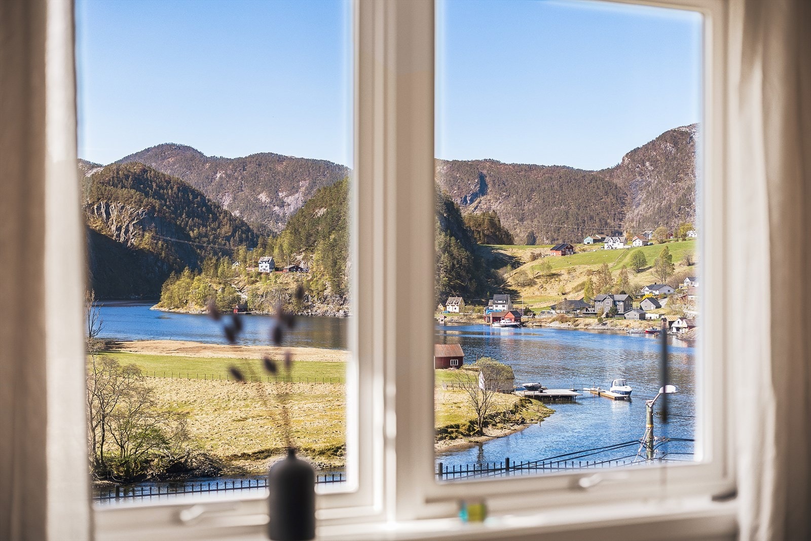 Nyt synet av fjorden og de grønne liene fra stuevinduet. Galleribilde