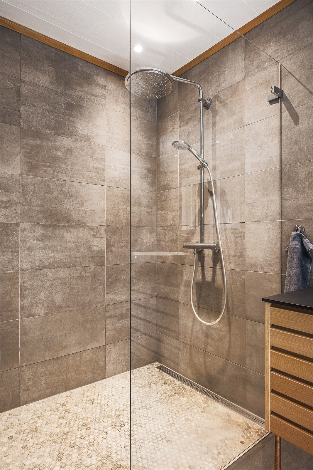 Dusjsonen har en elegant rainshower og mosaikkfliser på gulvet. Galleribilde