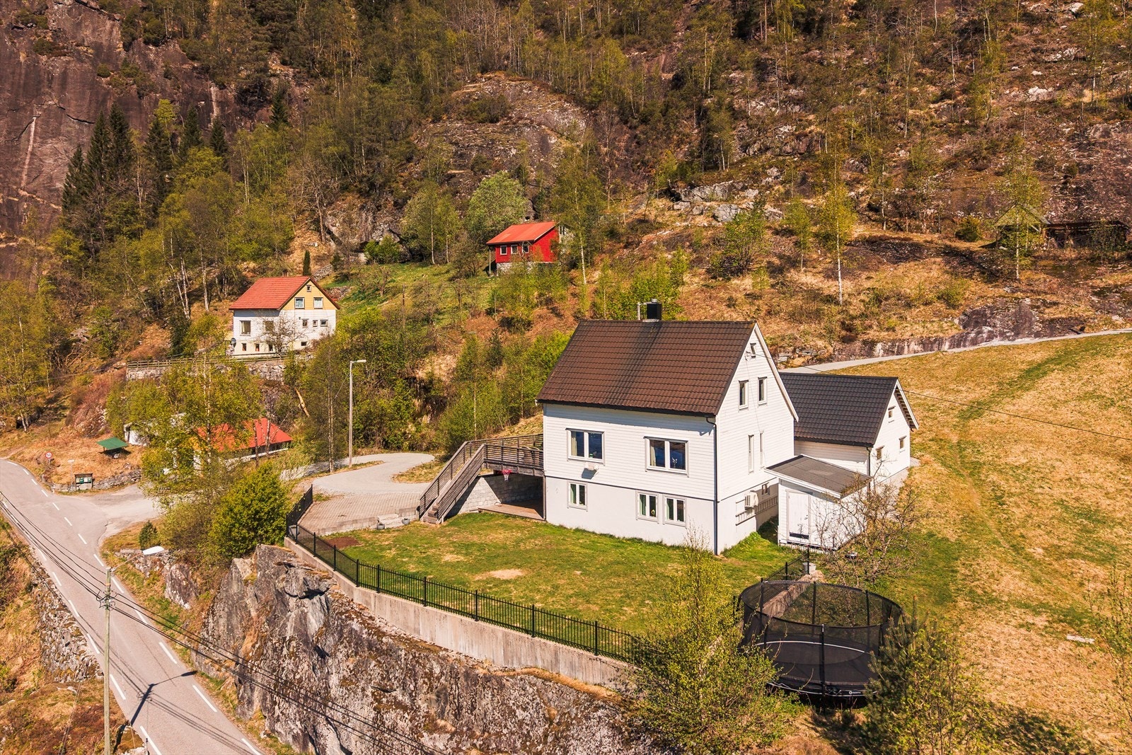 Tomten er av fin størrelse og plenen oppleves som flat. Rekkverket er laget av pulverlakkert stål og er levert av nordic fence. Trappen ned til plenen er i naturstein. Galleribilde