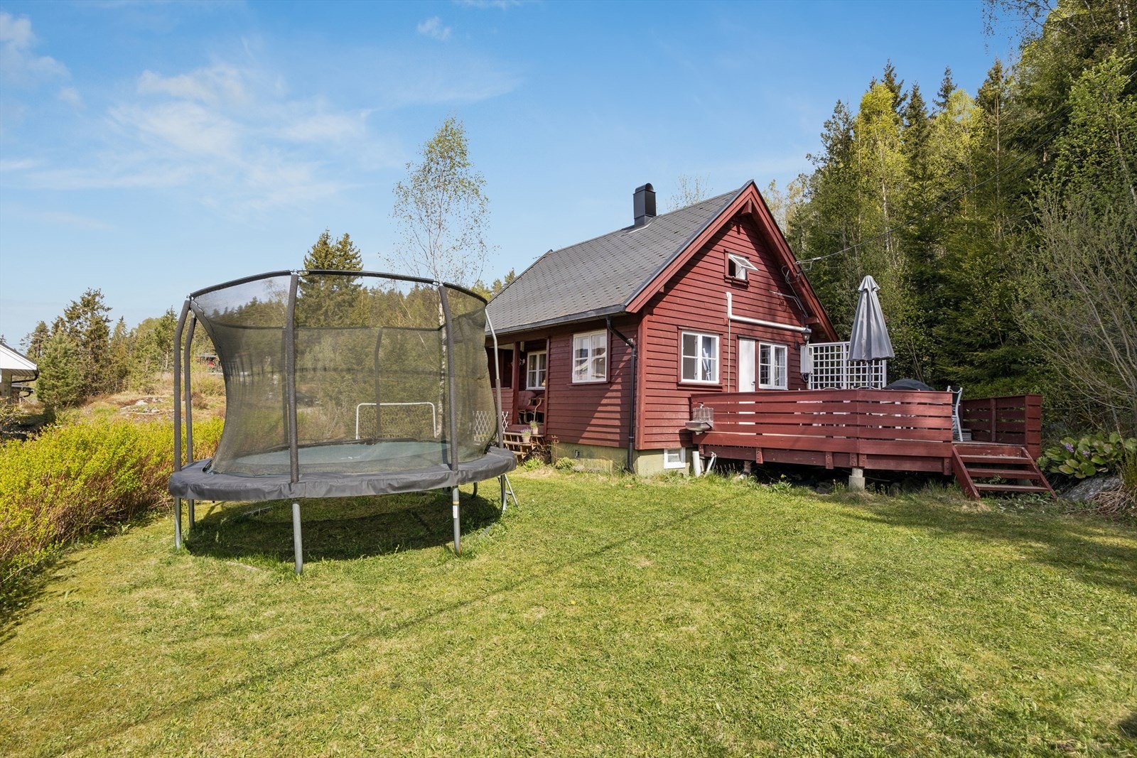 Tomten er opparbeidet med plen. Her finnes også et praktisk uthus med strøm, bodplass og forbrenningstoalett. Galleribilde