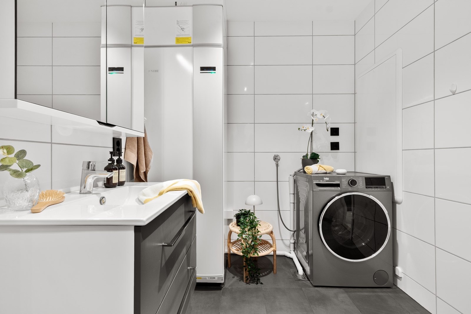 Badet er innredet på en slik måte at vaskemaskin og tørketrommel passer perfekt inn i rommet. Galleribilde