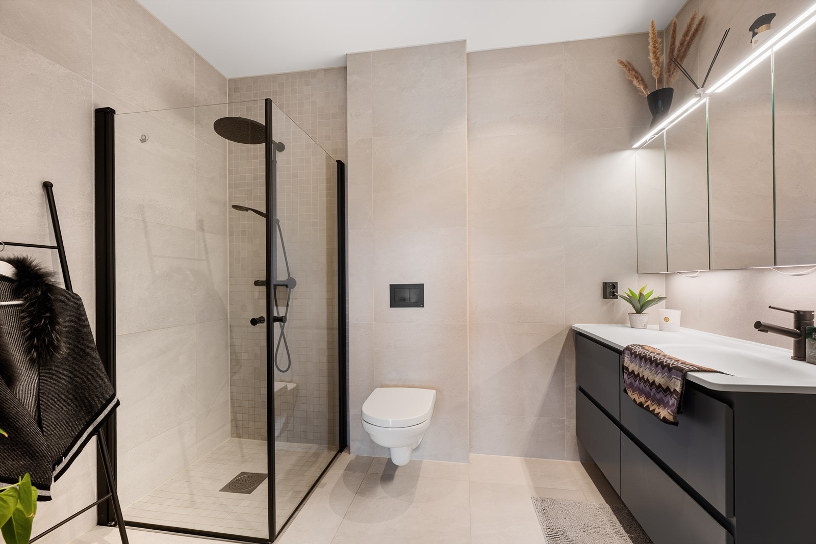 Badet til hovedsoverommet har tilvalg i forhold til standard oppsett - med store fliser på gulv og vegger i en lekker lys utførelse. Galleribilde