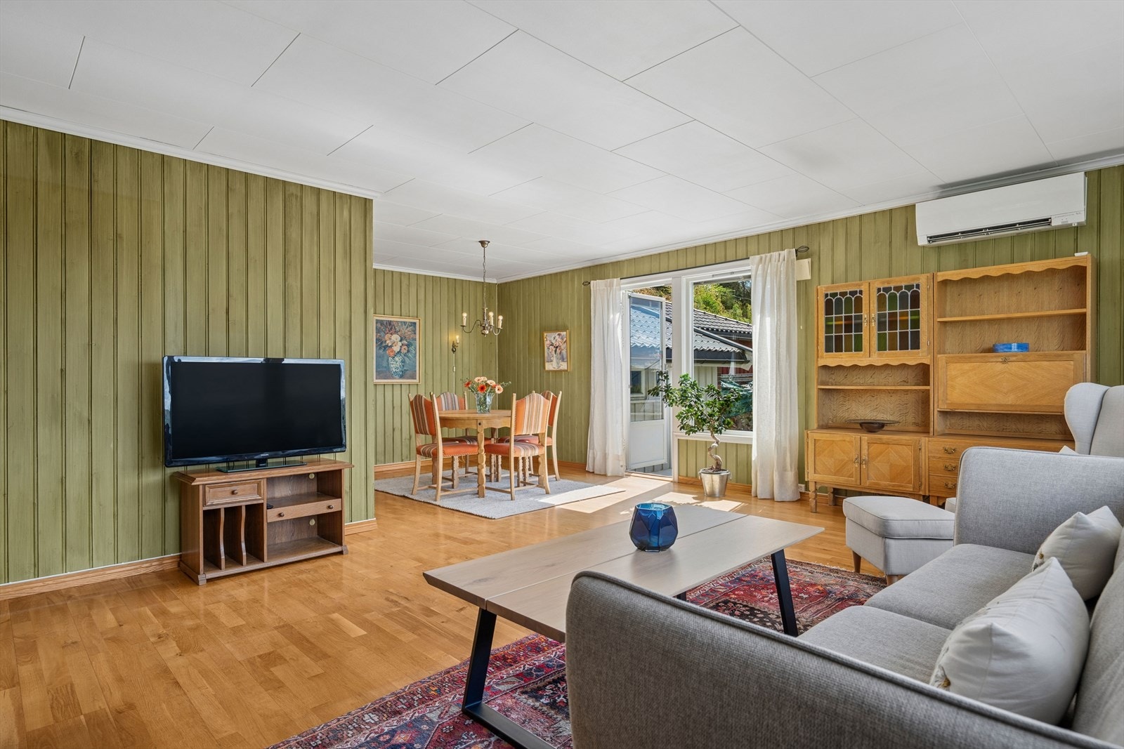 Gjennomgående parkett på gulvet i stuen og store vindusflater. Galleribilde