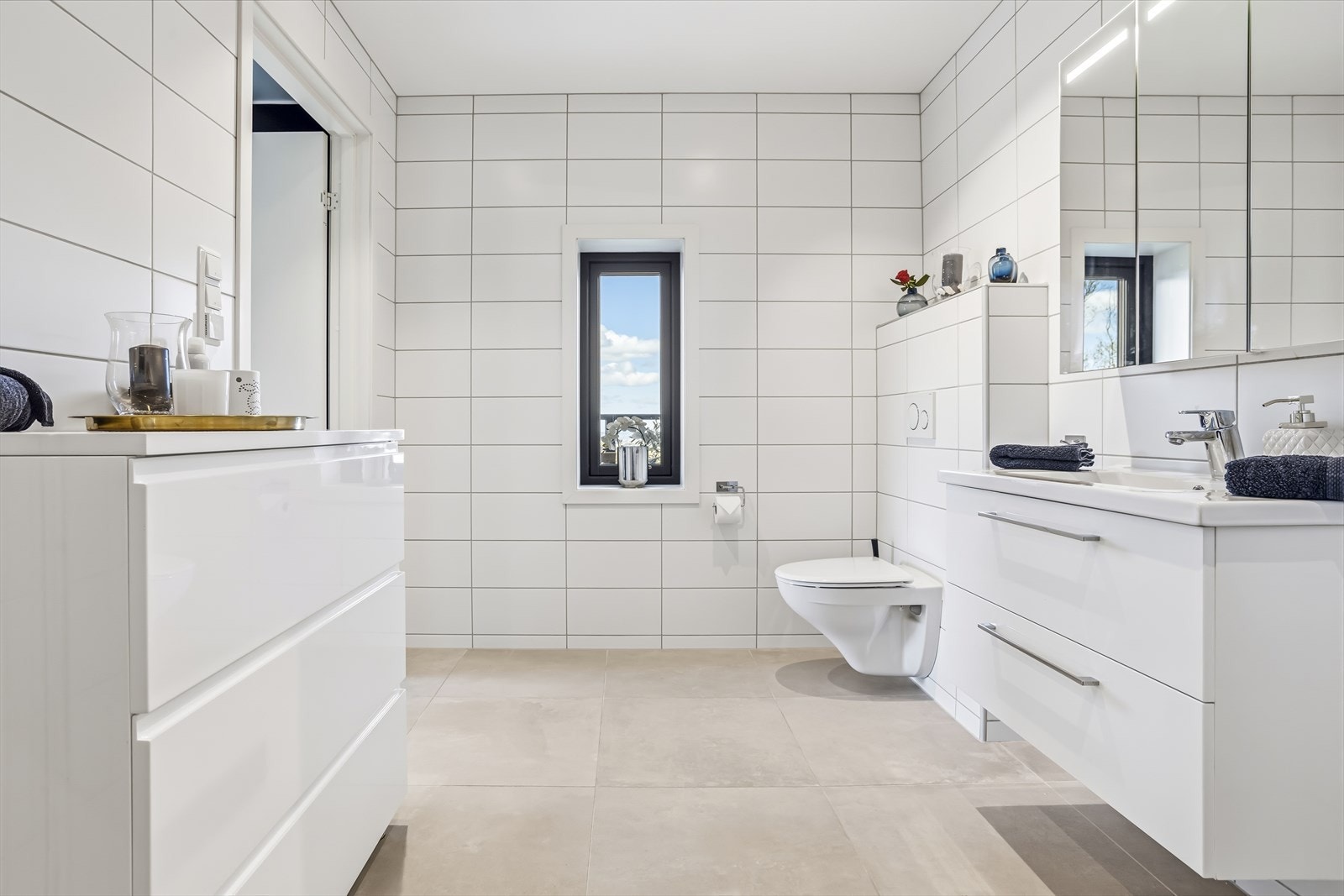 Badet er utstyrt med dusj, vegghengt toalett og servant med rikelig oppbevaringsplass. Galleribilde