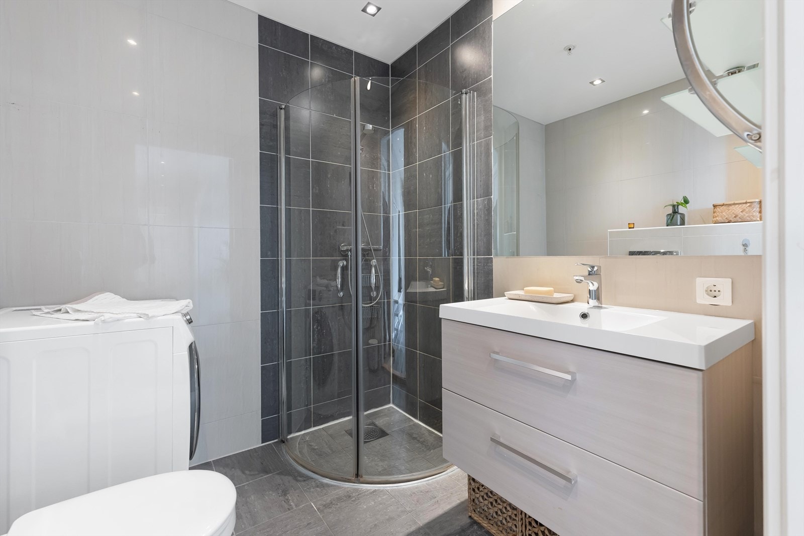 Badet er helfliset i tidløse farger og har en funksjonell innredning med servant og skuffer. Galleribilde