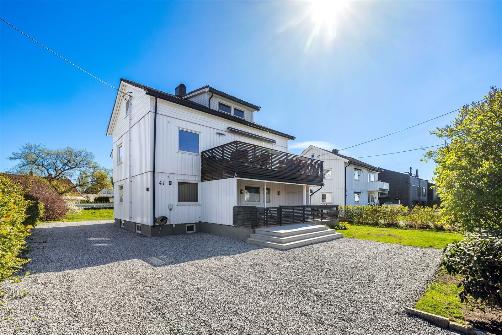 Gruset gårdsplass med biloppstillingsplasser. Denne seksjonen disponerer garasje ved inngangspartiet. Galleribilde