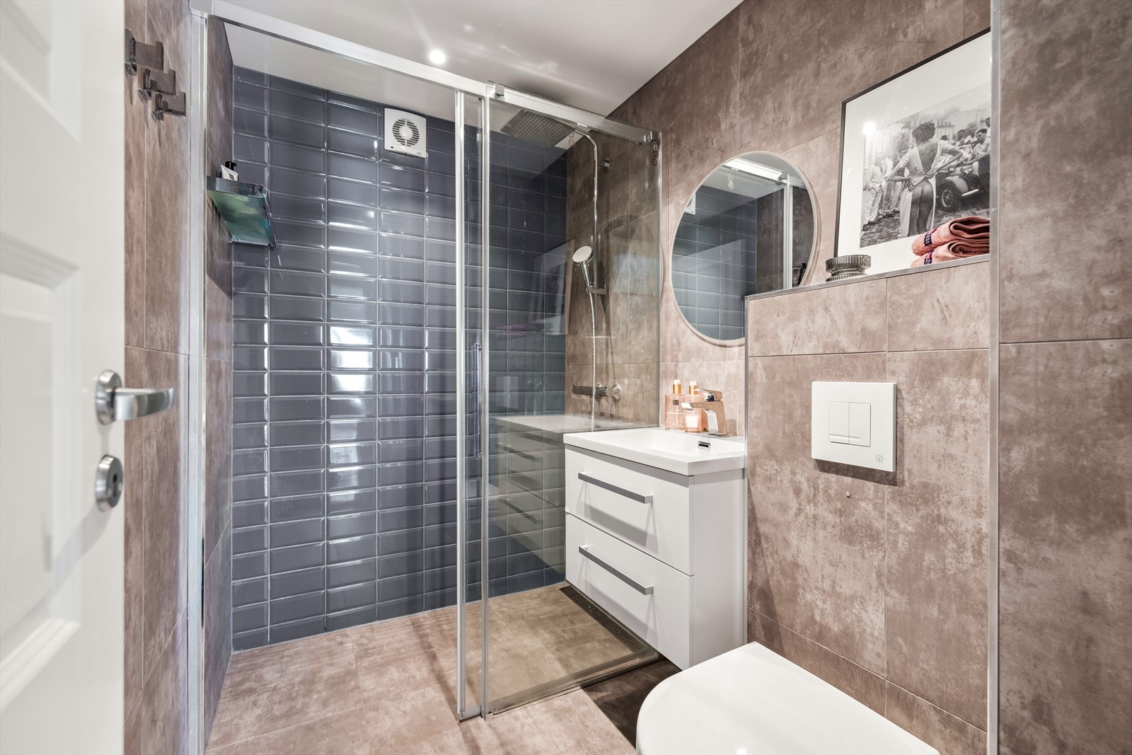 Badet er pusset opp i 2019 og har behagelig gulvvarme og downlights i taket. Stilig kontrastvegg med blå fliser i den romslige dusjsonen. Galleribilde