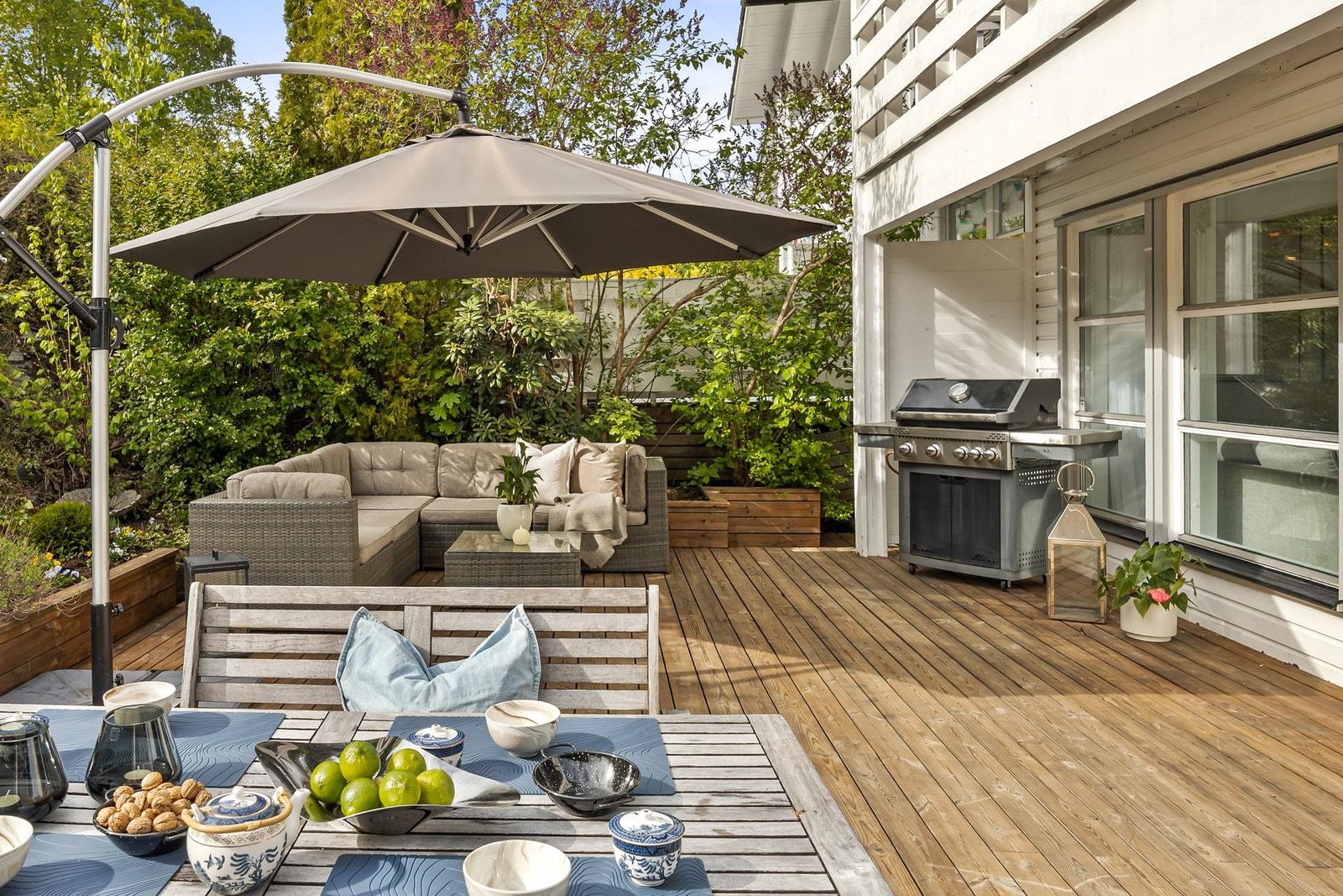 Lounge med parasoll og plass til grill like ved inngangen til stuen. Galleribilde