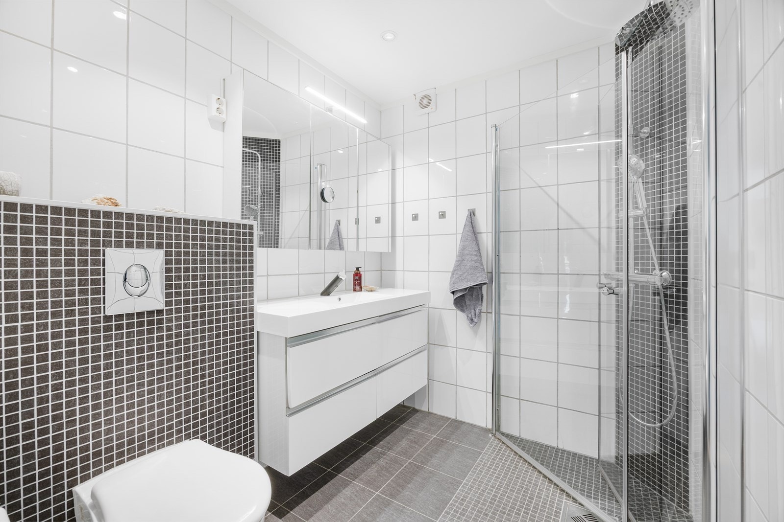 Badet i første etasje er flislagt og har elektrisk gulvvarme, vegghengt toalett og dusjnisje. Galleribilde