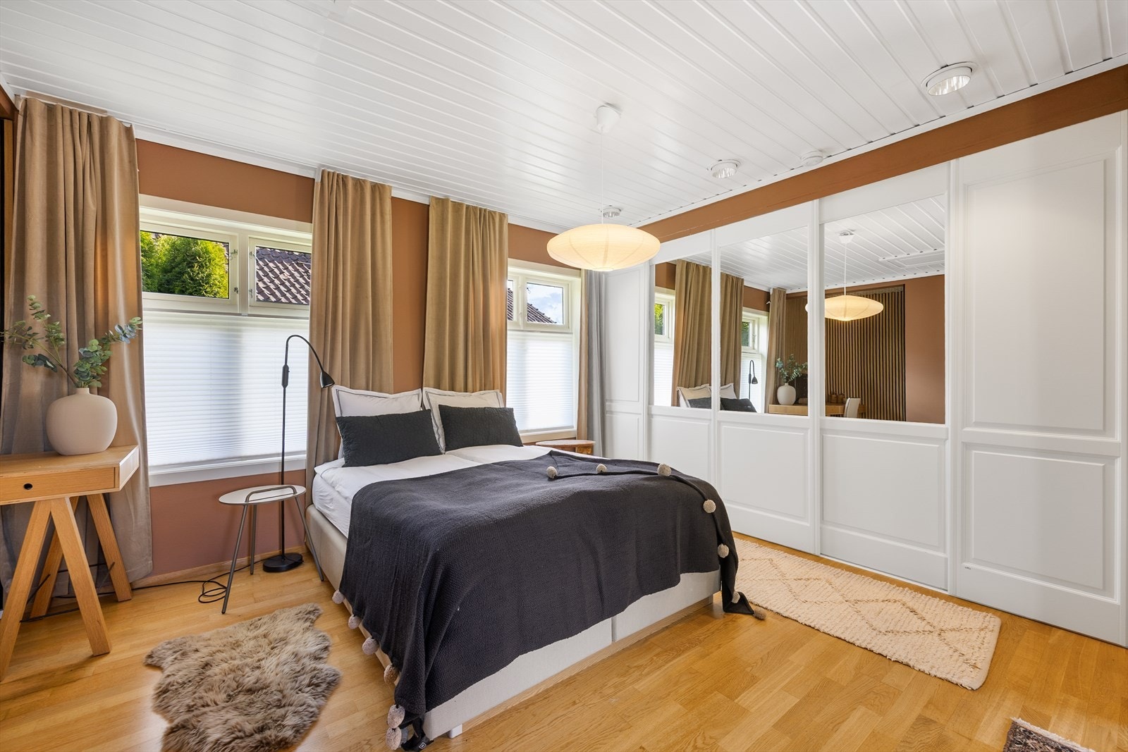 En stor skyvedørsgarderobe med speilfronter gir rikelig med oppbevaringsplass på hovedsoverommet. Galleribilde