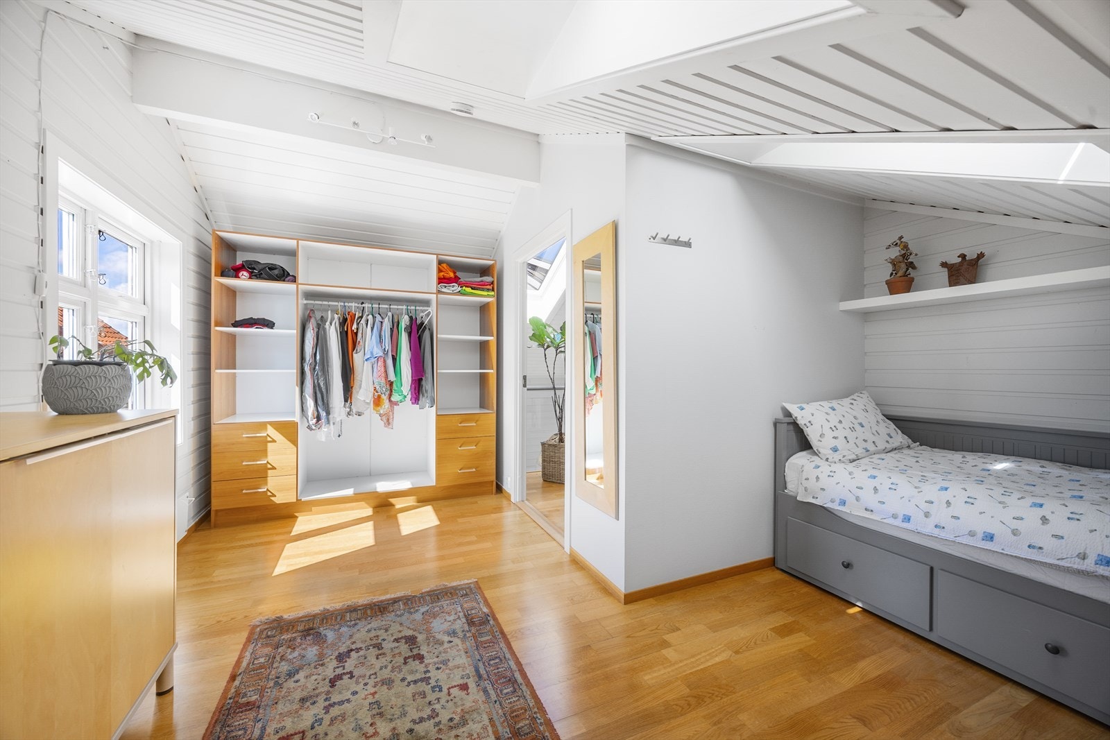 Det andre soverommet har en stor, åpen garderobe og parkett på gulvet. Galleribilde
