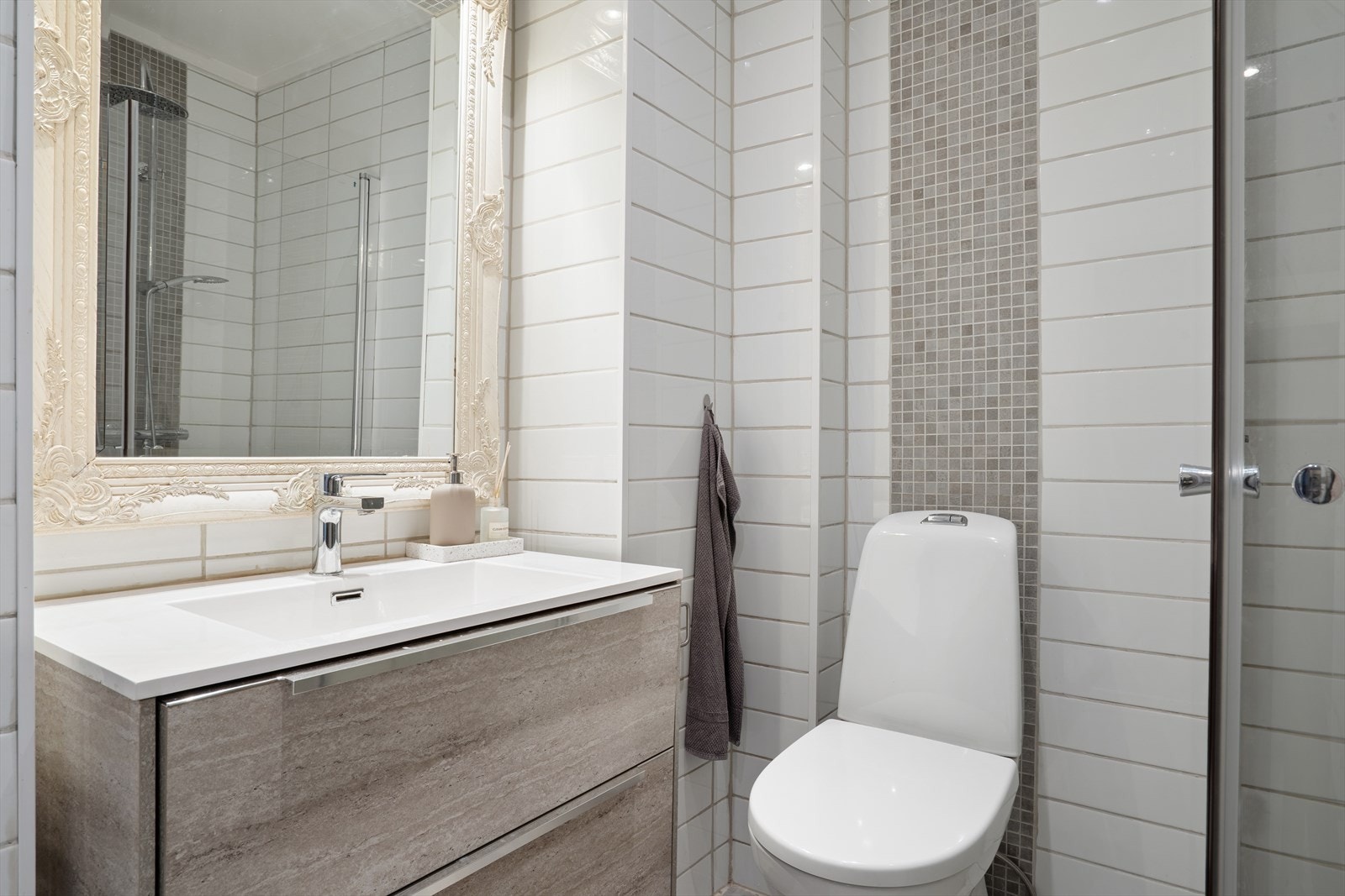 Badet har lyse motiver og tidløse overflater med flis på vegg og gulv. Galleribilde