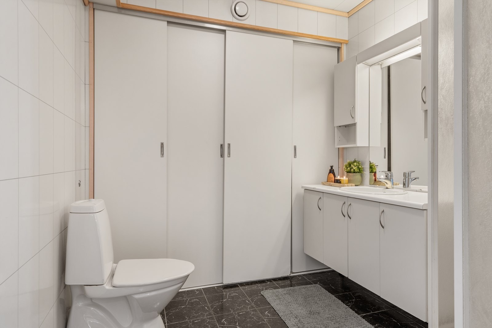 Badet er utstyrt med flislagt gulv med varmekabler, dusjkabinett og opplegg for vaskemaskin. Galleribilde