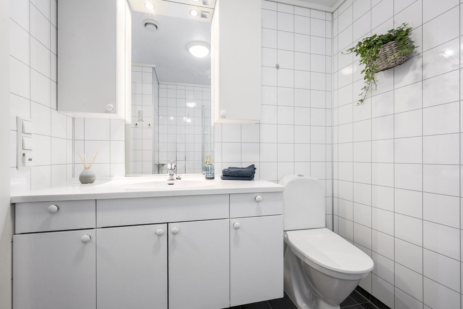 Baderomsinnreiing med heilforma servant og opplegg for vaskemaskin. Galleribilde