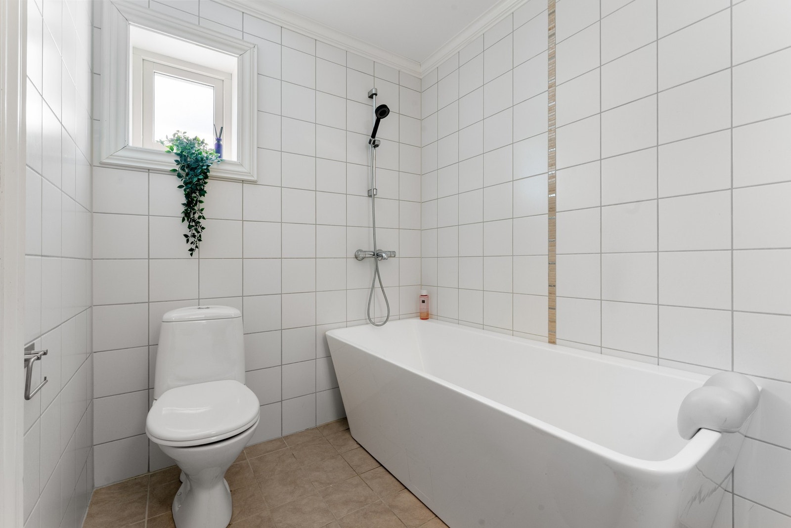 Badet er innredet med badekar m/dusj, toalett og baderomsinnredning med heldekkende servant samt belyst speil Galleribilde