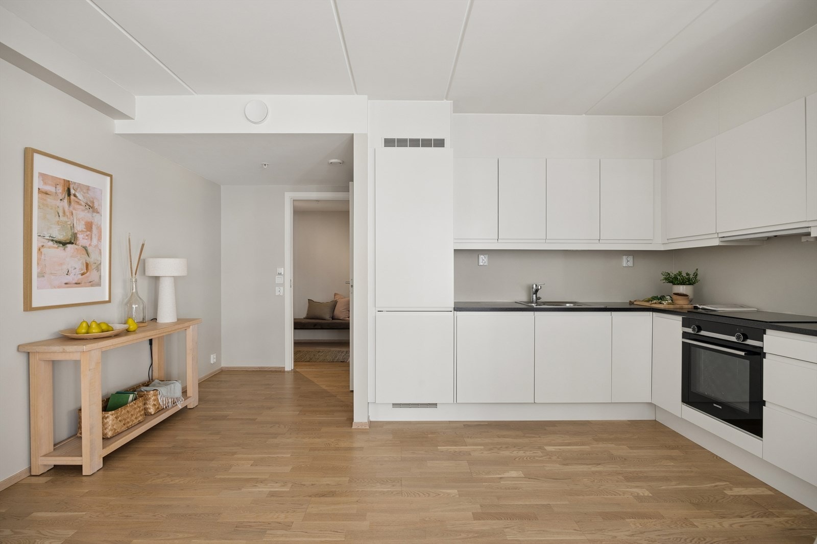 Kjøkkenet har parkett på gulvet, malte plater på veggene og malte betongelementer i himlingen. Kjøkkeninnredning med malte glatte fronter, laminat benkeplate, ventilator og stål benkebeslag. Galleribilde