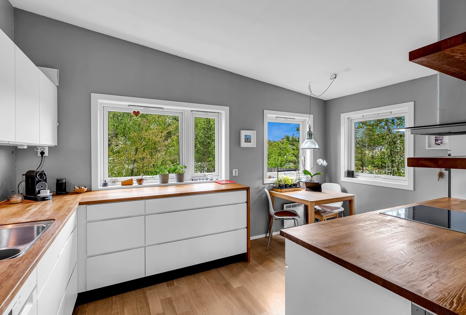 Kjøkken i lyse og moderne utførelser med glatte fronter og benkeplate i heltre. Galleribilde