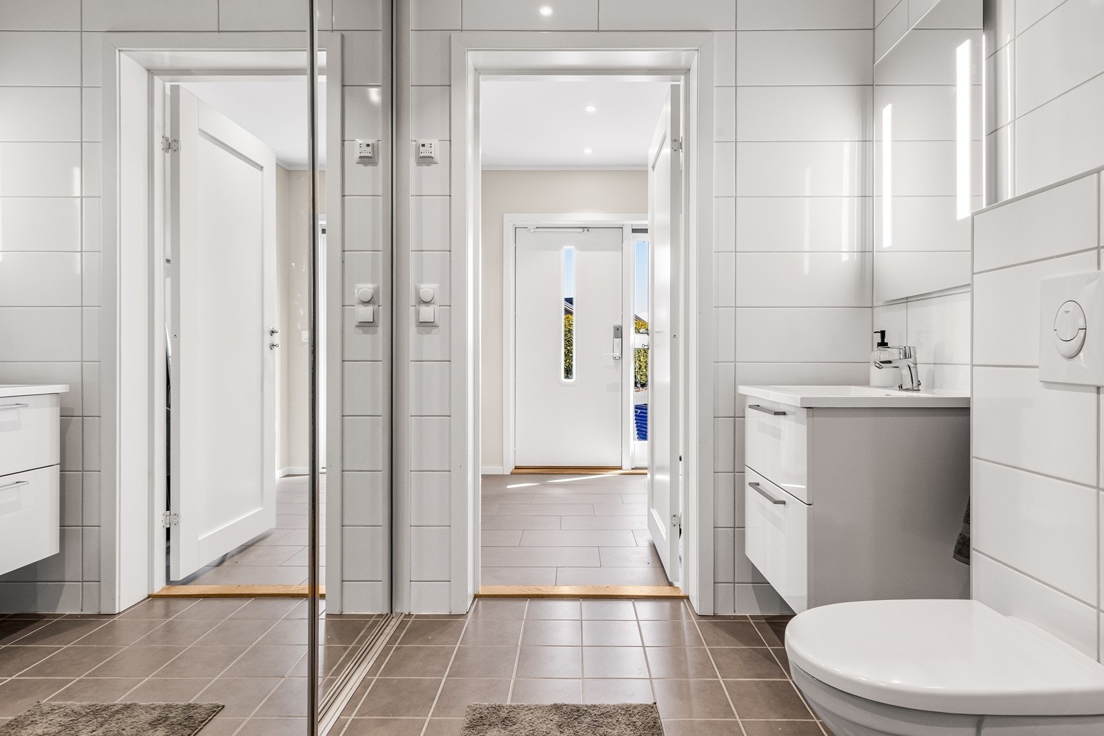 Badet i første etasje har plassbesparende skyvedører som skjuler vaskemaskin og tilhørende opplegg. Galleribilde