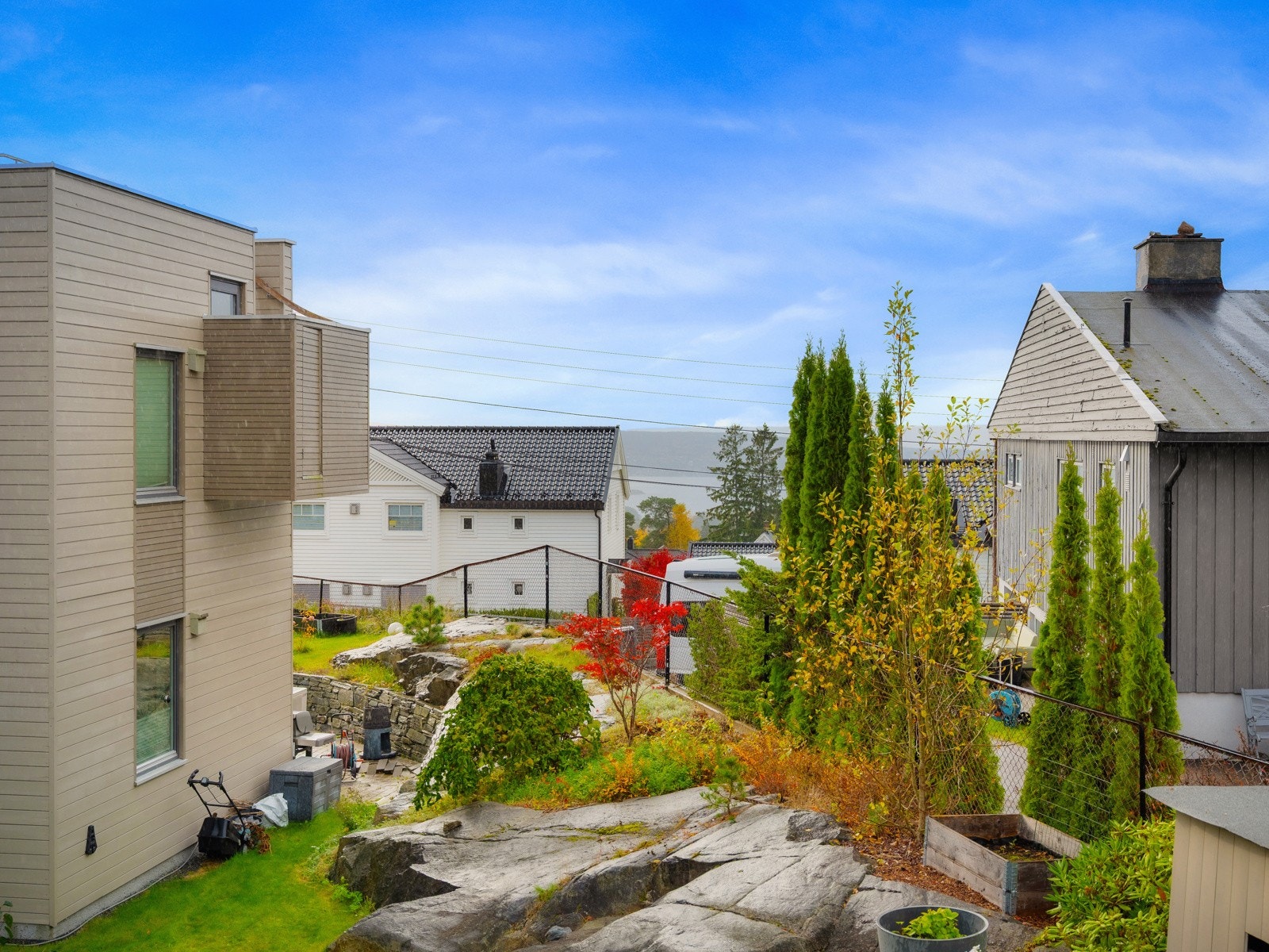 De naturlige bergene gir et fint uttrykk og skaper variasjon i terrenget, mens hekk og beplantning rundt eiendommen gir en behagelig ramme. Galleribilde