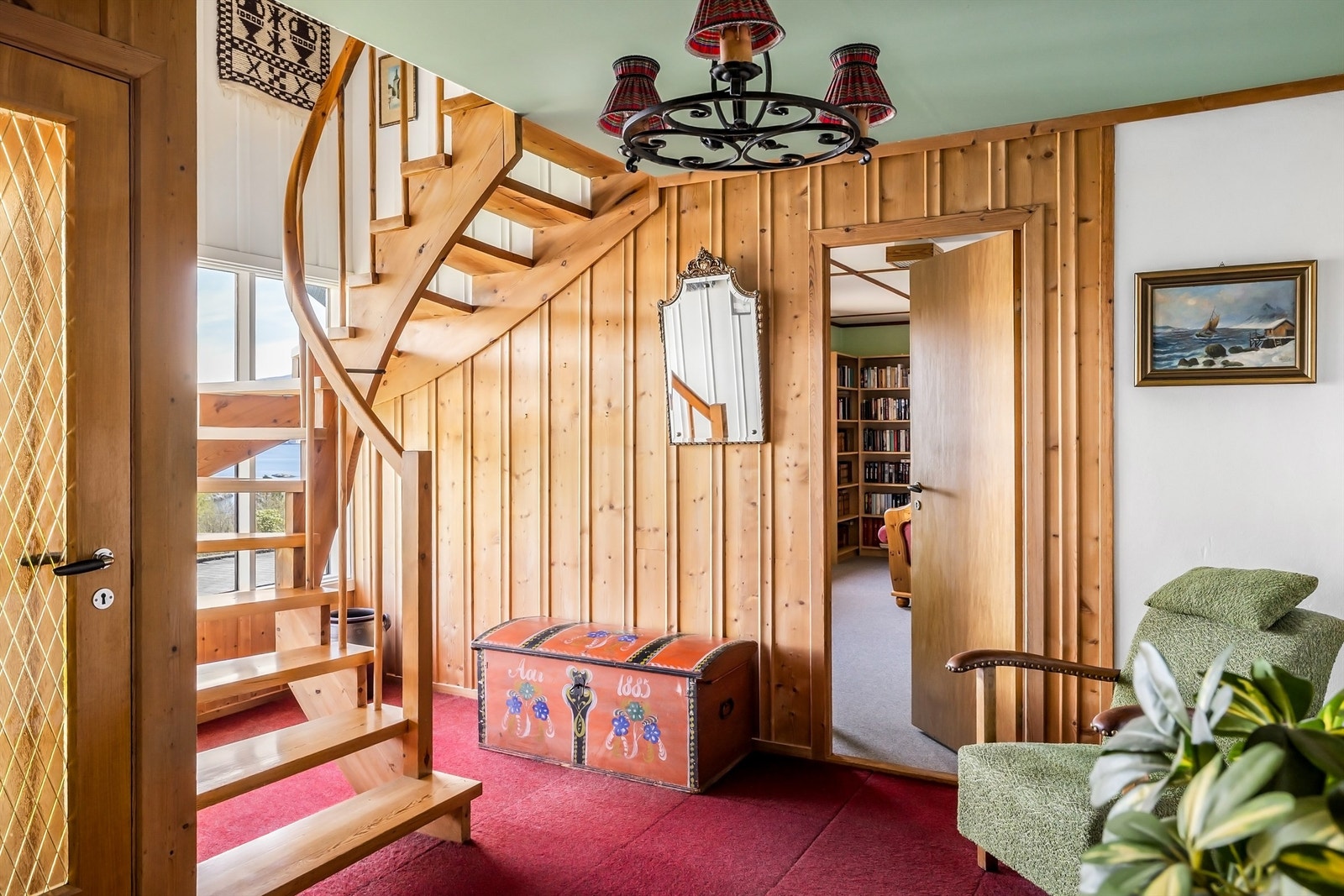 Hallen i første etasje har en lakkert tretrapp som forbinder de to planene. Herfra er det inngang til stue og bibliotek. Galleribilde