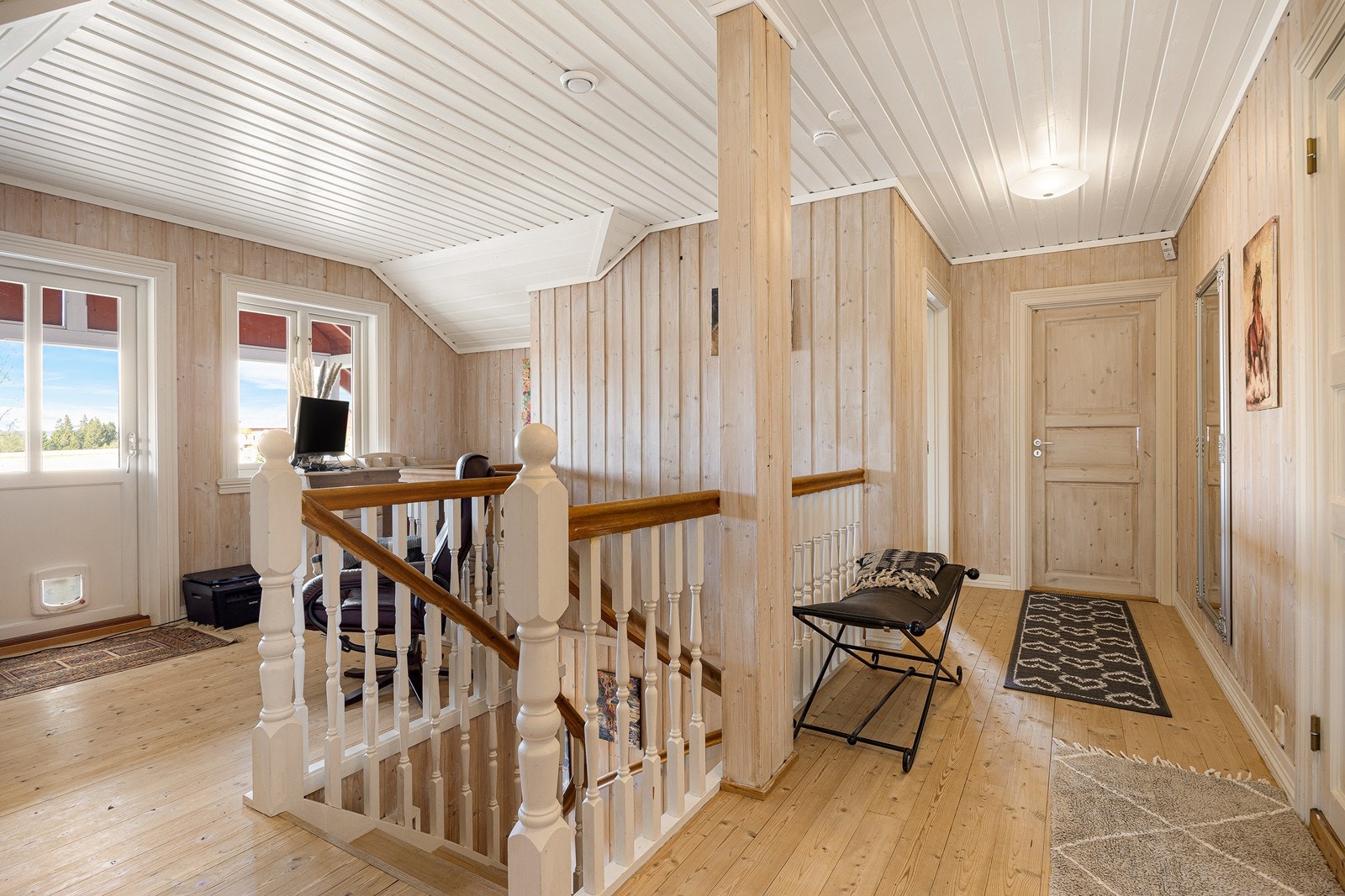 Trapperommet i etasjen er åpent og lyst. Ved balkongdøren er det plass til en liten lesekrok. Galleribilde