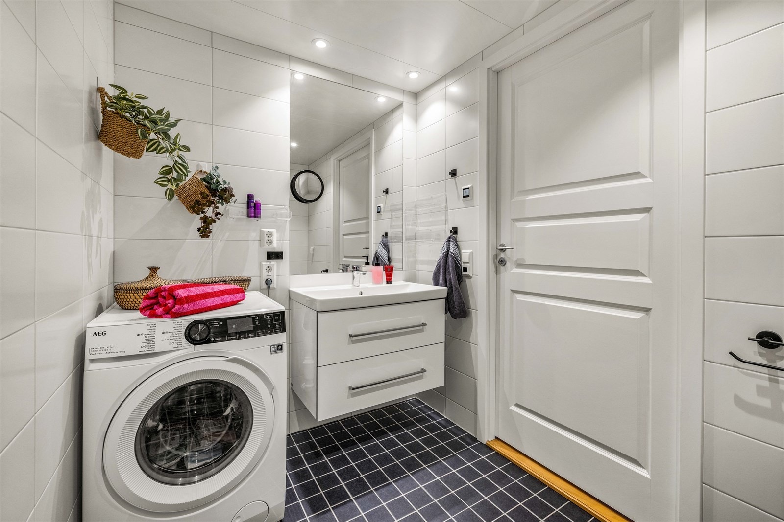 Tidløst og flislagt baderom med gulvvarme, downlights og mekanisk avtrekk. Det er opplegg for både vaskemaskin og tørketrommel. Galleribilde