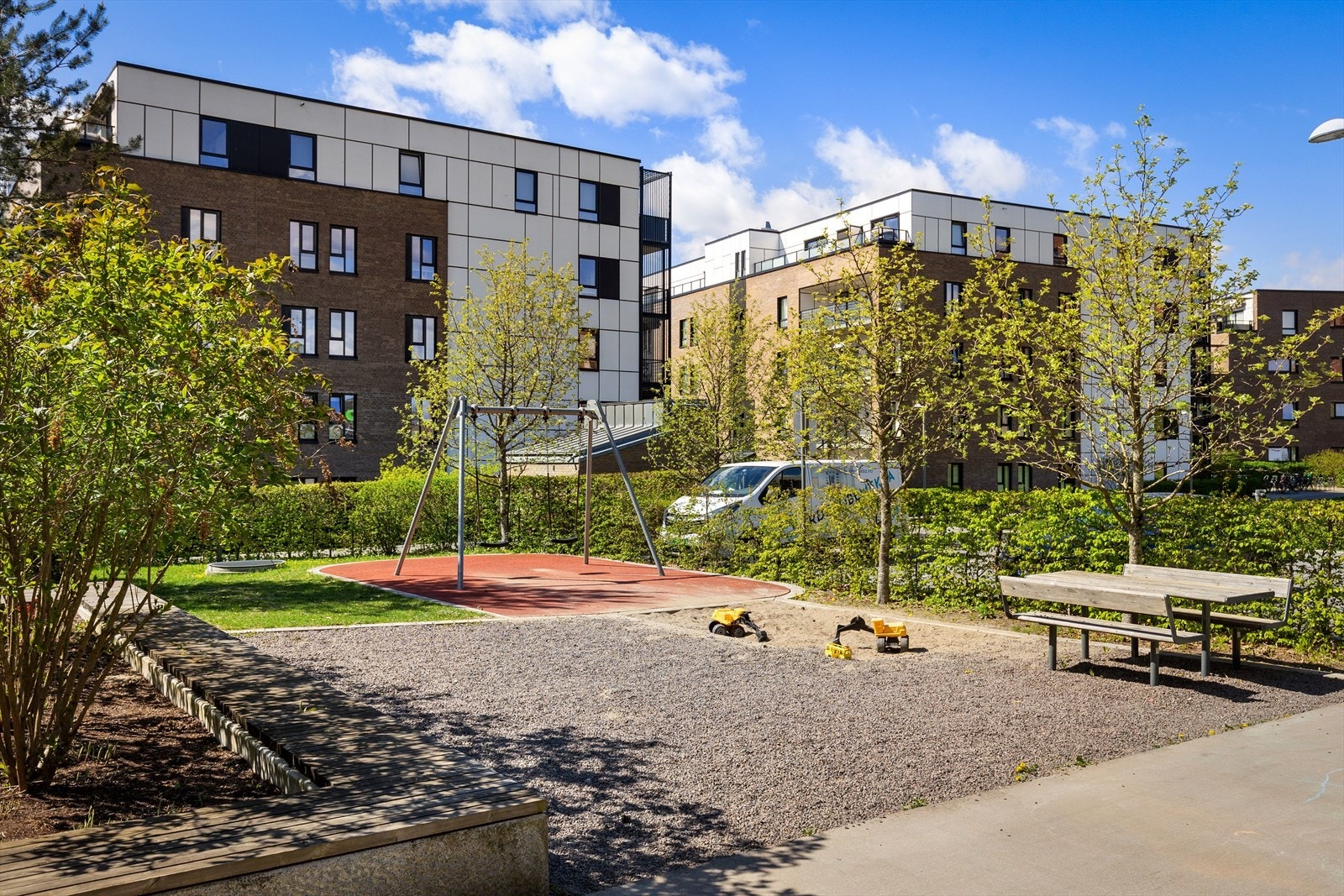 Bakgård med hyggelige grøntarealer, sittebenker og lekeplass Galleribilde