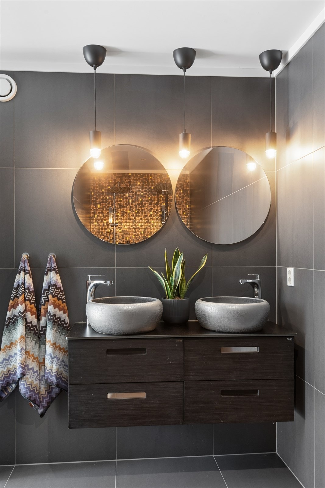 Badet er delikat innredet med doble, overliggende bolleservanter og downlights. Galleribilde