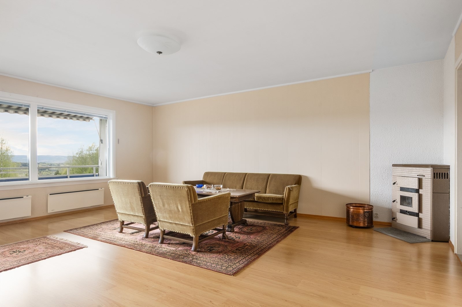 Stuen er romslig, så her kan du trygt ta med deg både sofa, spisebord, stor TV og kanskje til og med en skikkelig godstol til å ha foran vedovnen! Galleribilde