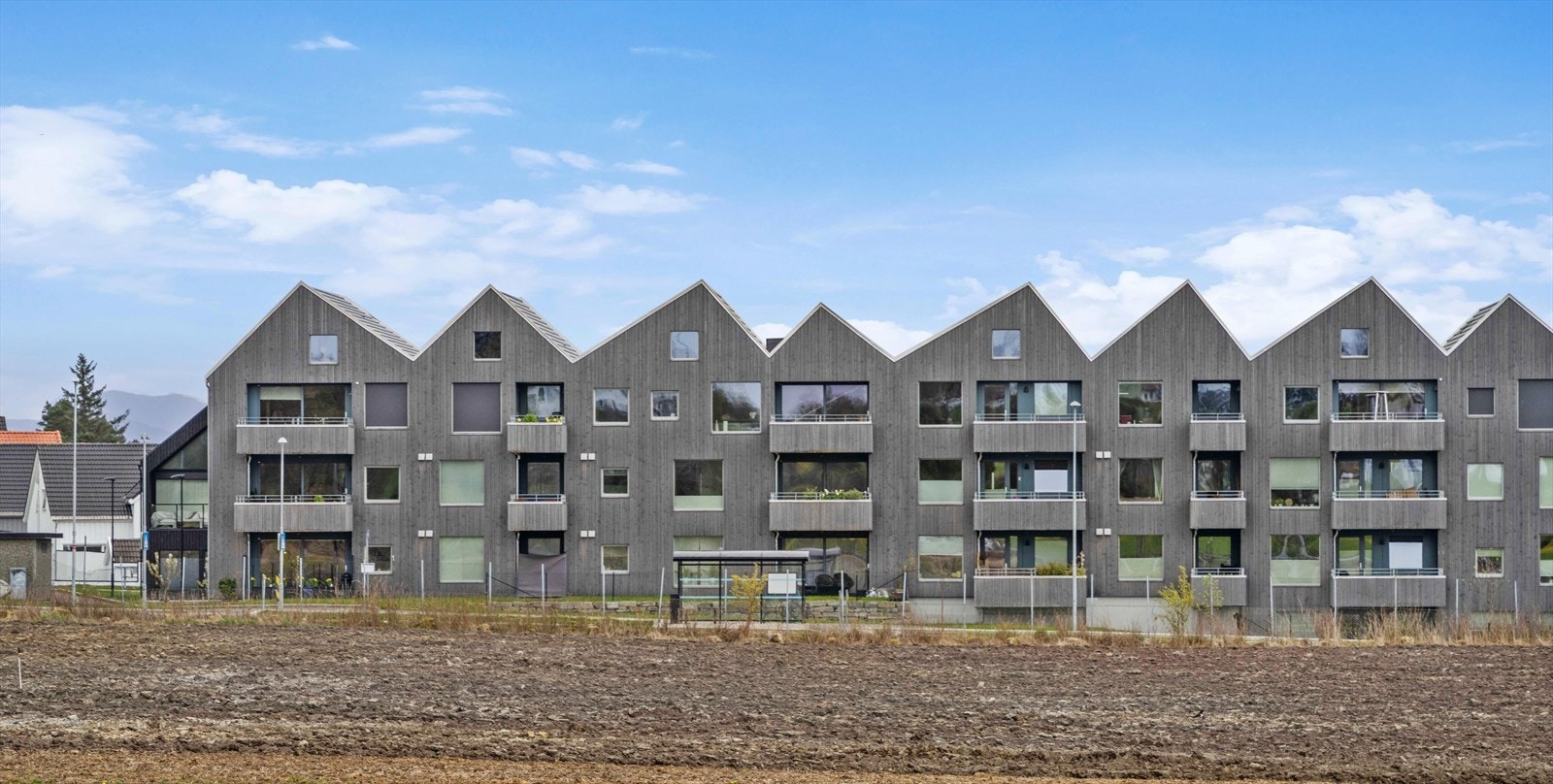 Bygget fra 2021 har en moderne arkitektur med stående bordkledning og karakteristisk saltaksform. Galleribilde