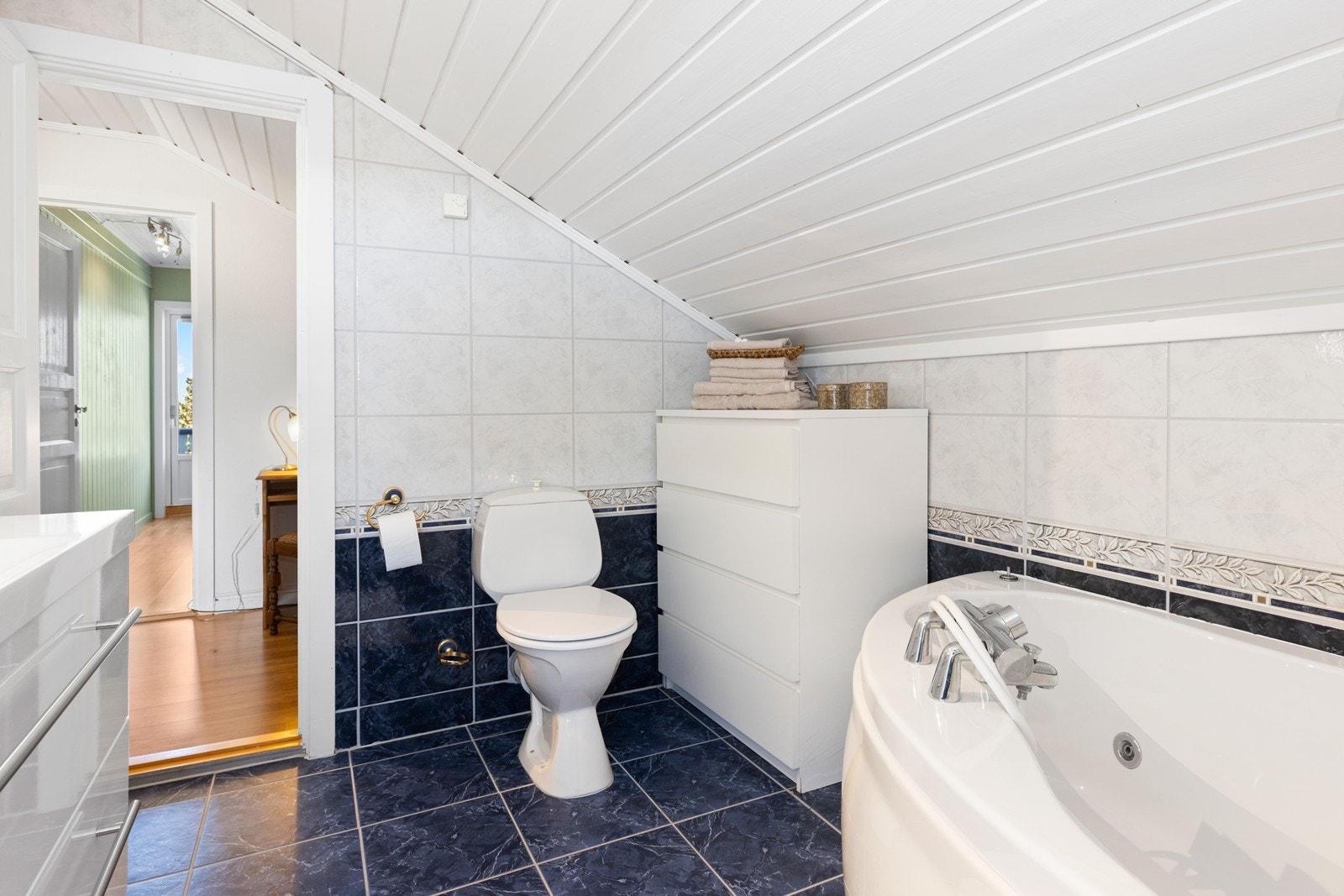 Flislagt bad i 2. etasje med toalett, badekar og skapinnredning med servant. Galleribilde